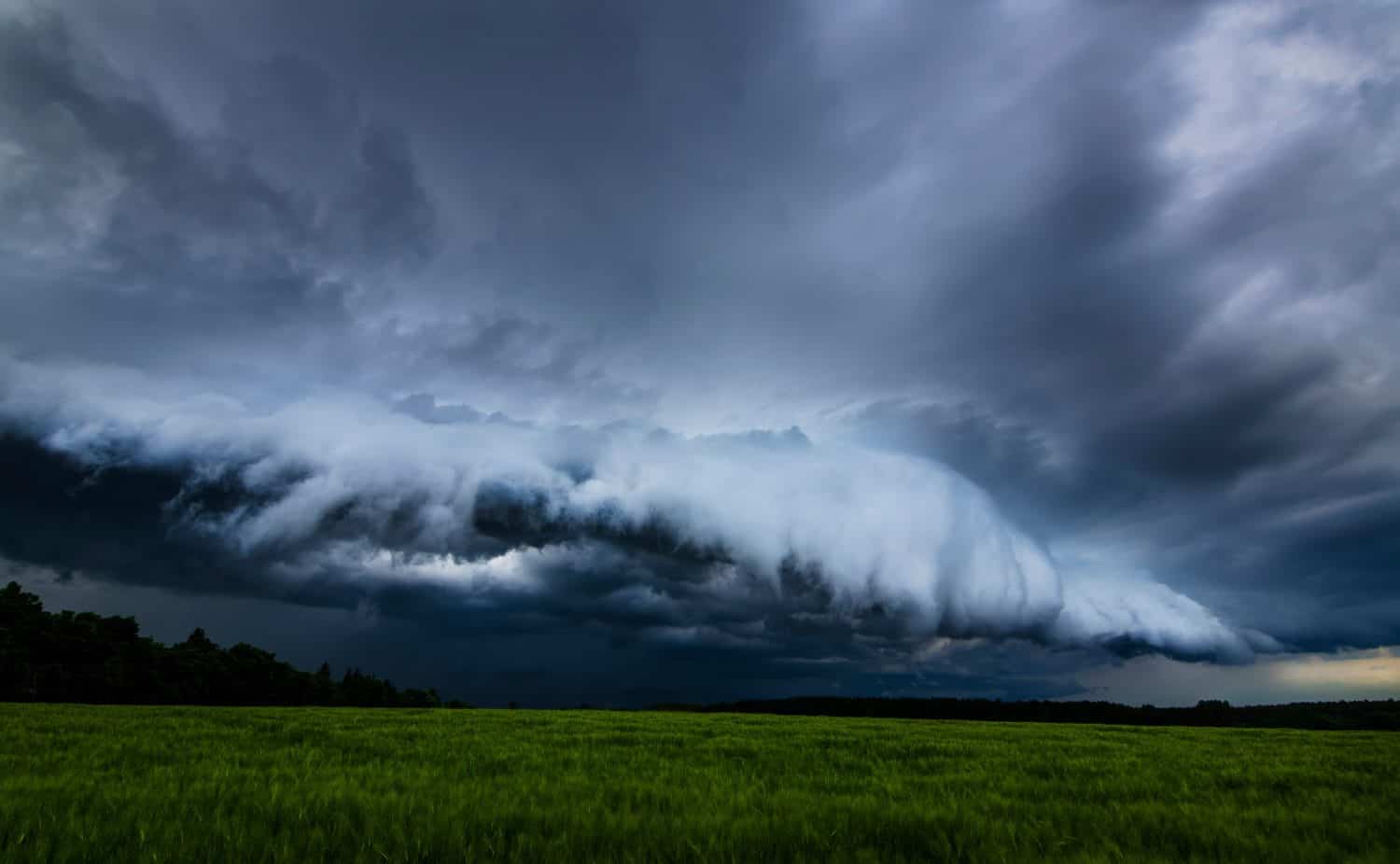 Storm clouds over field, tornadic supercell, extreme weather, dangerous storm, climate change