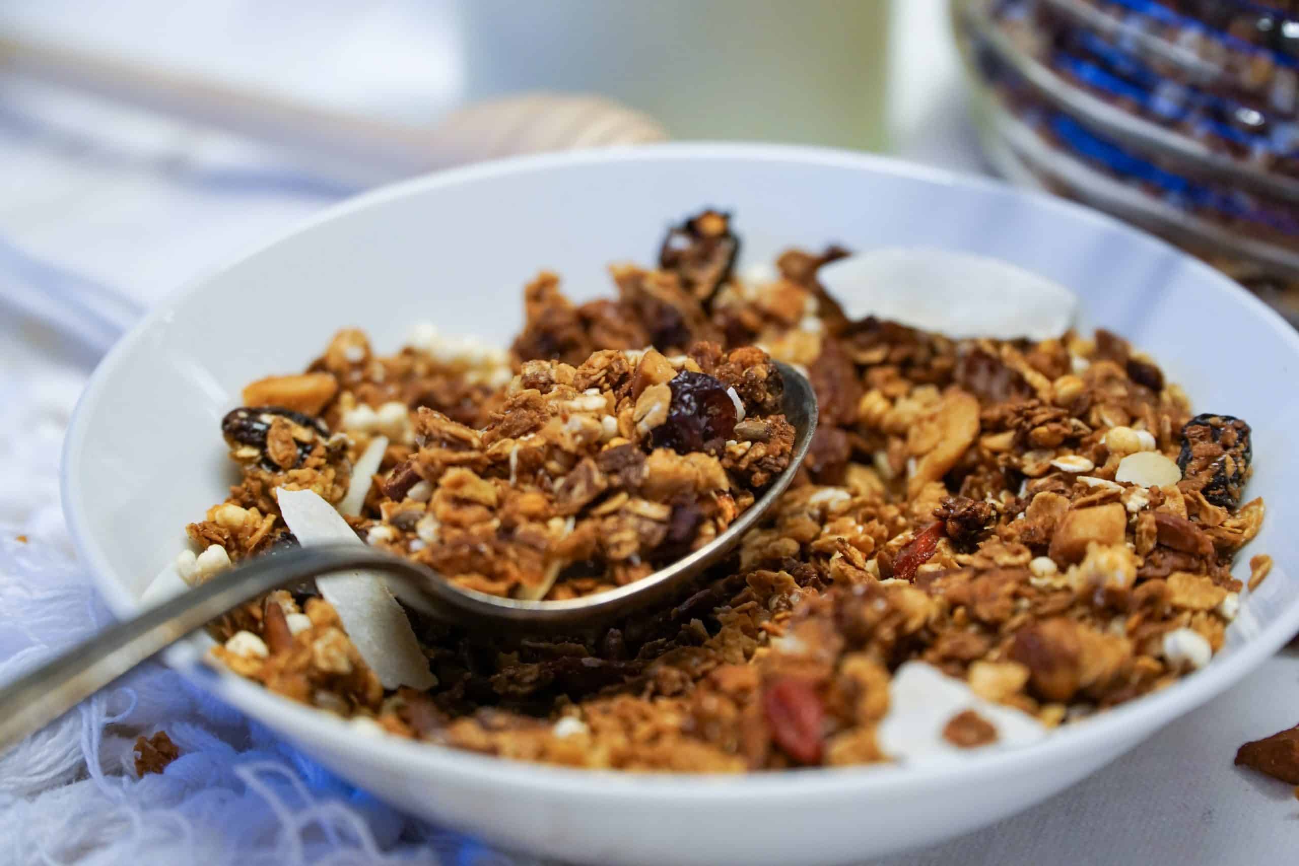 A close-up view of a bowl filled with granola, displaying its wholesome blend of oats, nuts, seeds, and dried fruits, ready to be savored for a delightful and nutritious meal.