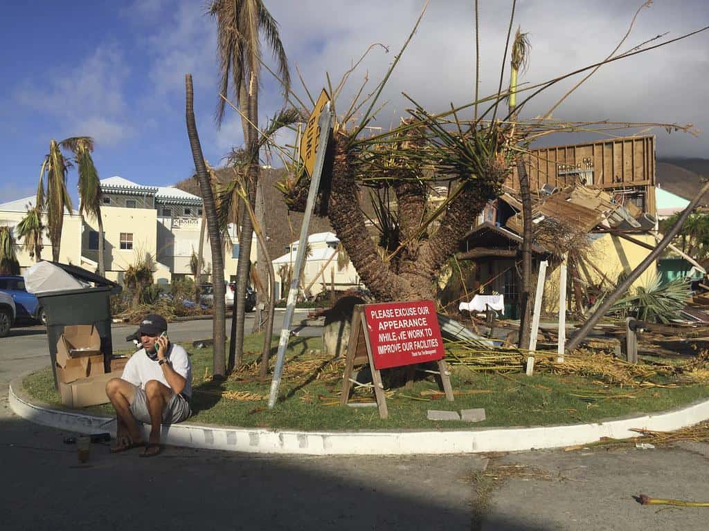 A man sits next to sign in the marina of Nanny Cay on the British Virgin Island of Tortola, which suffered widespread damage and destruction when Hurricane Irma passed over on 6 September 2017. by DFID - UK Department for International Development