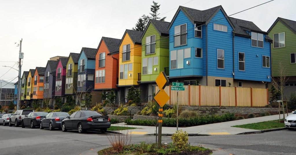 Colorful row of houses, blue, green, yellow, orange, blue, green, pink, purple, orange, yellow, green, blue, black and silver cars, street sign, N 35th and Meridian Ave N, Seattle, Washington, USA by Wonderlane