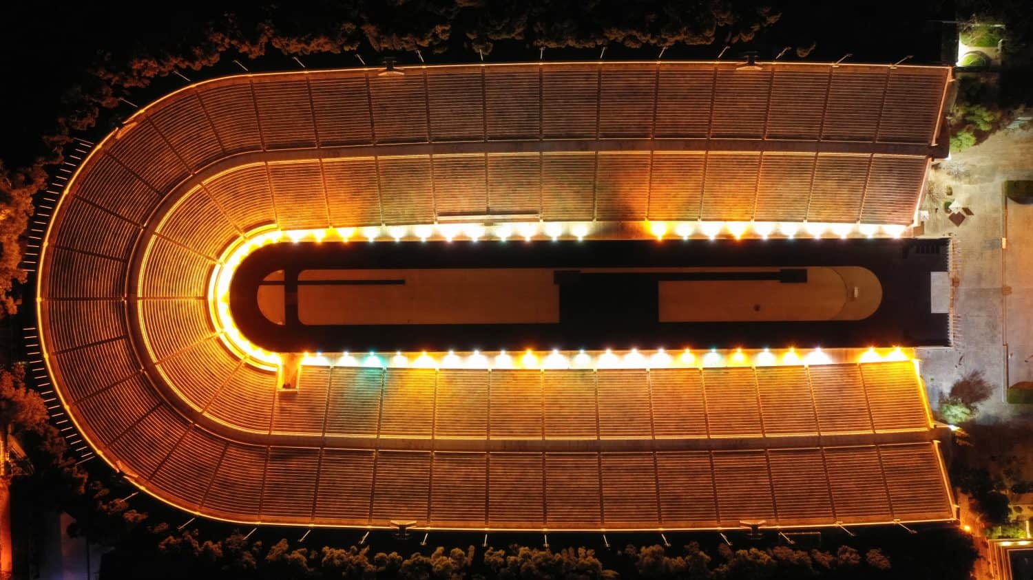 Aerial drone top down night shot of illuminated Athens ancient Kalimarmaro stadium or Panathenaic where original Olympic games were held, Attica, Greece