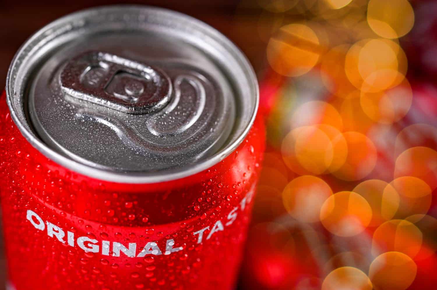 A can, tin of fresh Coca Cola drink with brick wall backround. Coca-Cola company is the most popular brand in the world.