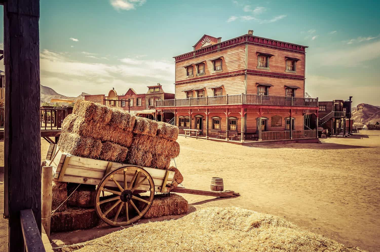 Town square as a western movie set. Spaghetti western. Cart loaded with straw bales. Travel concept