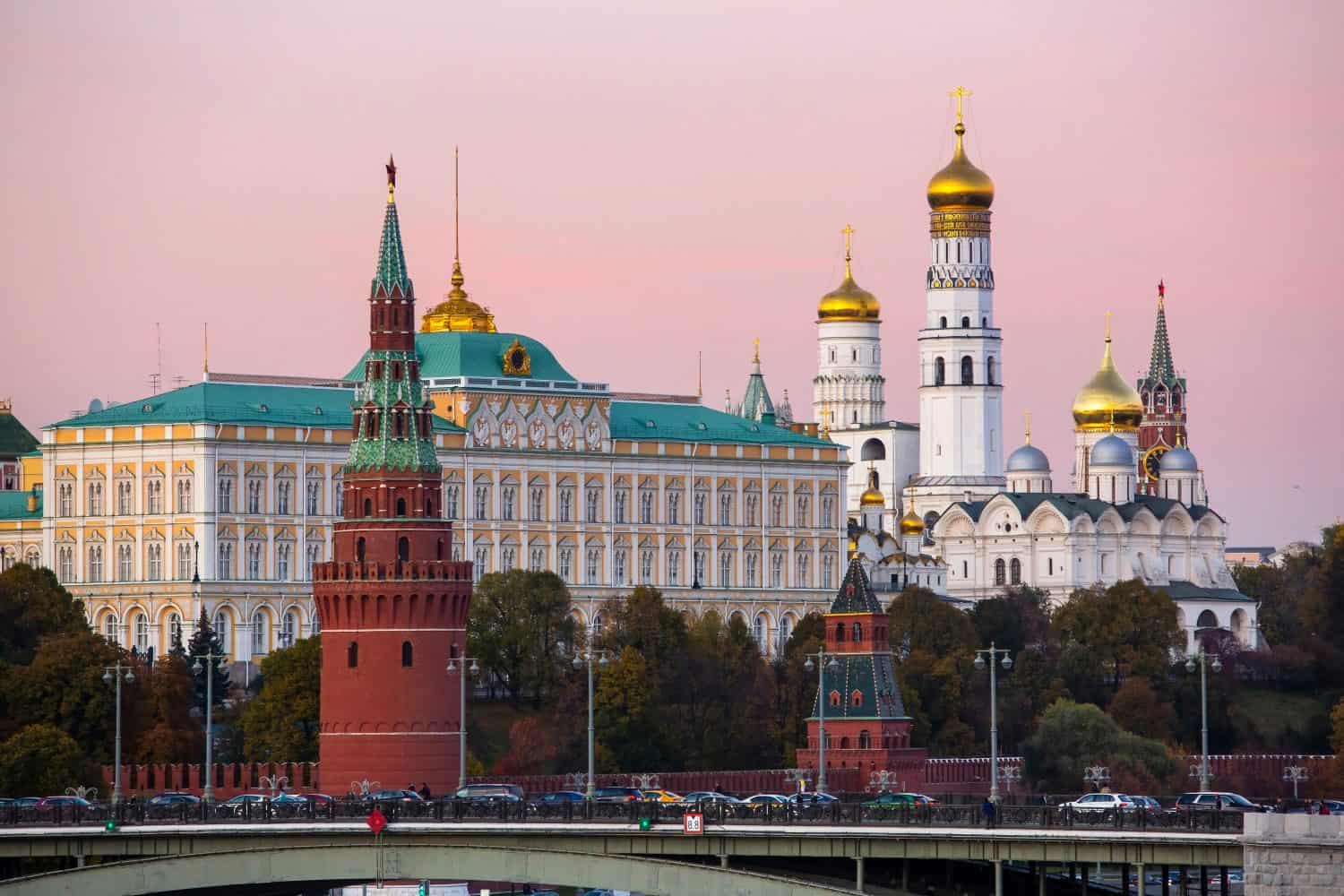 View of the tower, palace and orthodox cathedral in the Kremlin at sunset against a pink sky in Moscow, Russia