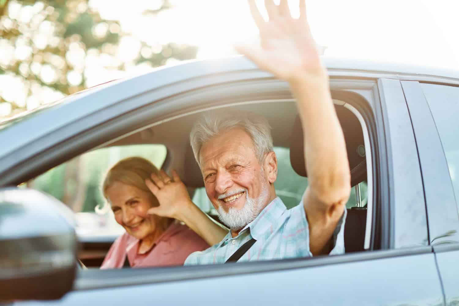 Happy senior couple going on a trip in their car