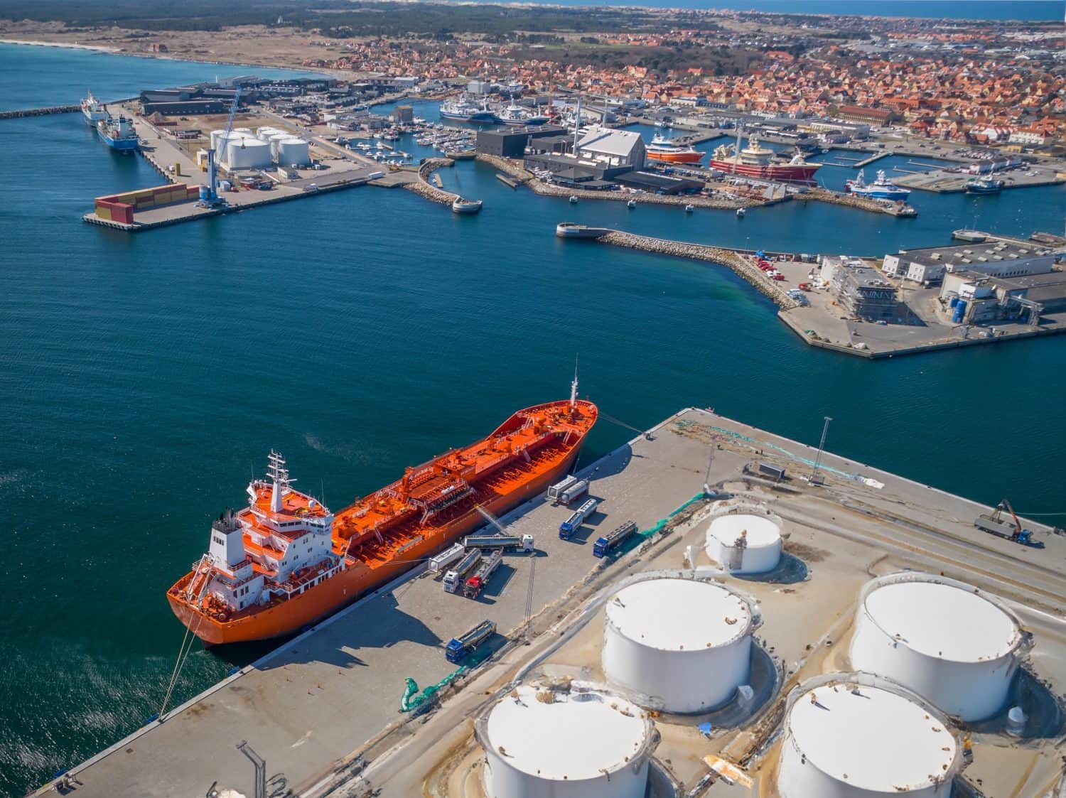 The ship-tanker with oil is unloaded in the fuel trucks in port. Fuel truck in the tank takes out fuel from the tanker. Discharging from tanker to truck.