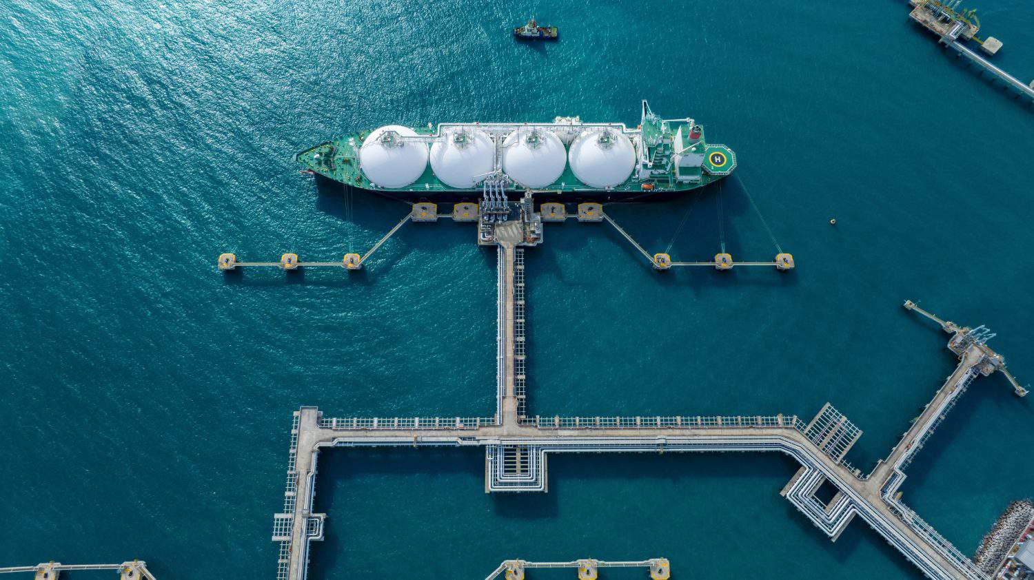 LNG (Liquified Natural Gas) tanker anchored in Gas terminal gas tanks for storage. Oil Crude Gas Tanker Ship. LPG at Tanker Bay Petroleum Chemical or Methane freighter export import transportation