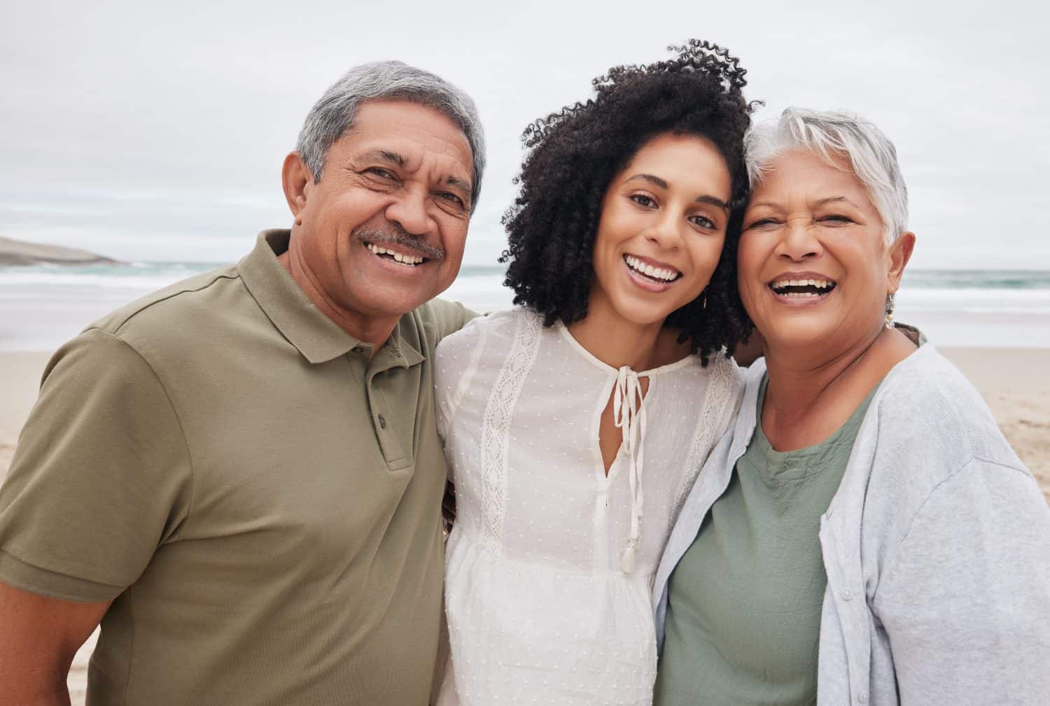 Portrait, happy woman and senior parents at beach on holiday, vacation or travel outdoor. Face, adult daughter and mother and father bonding together at ocean for family connection, love and support