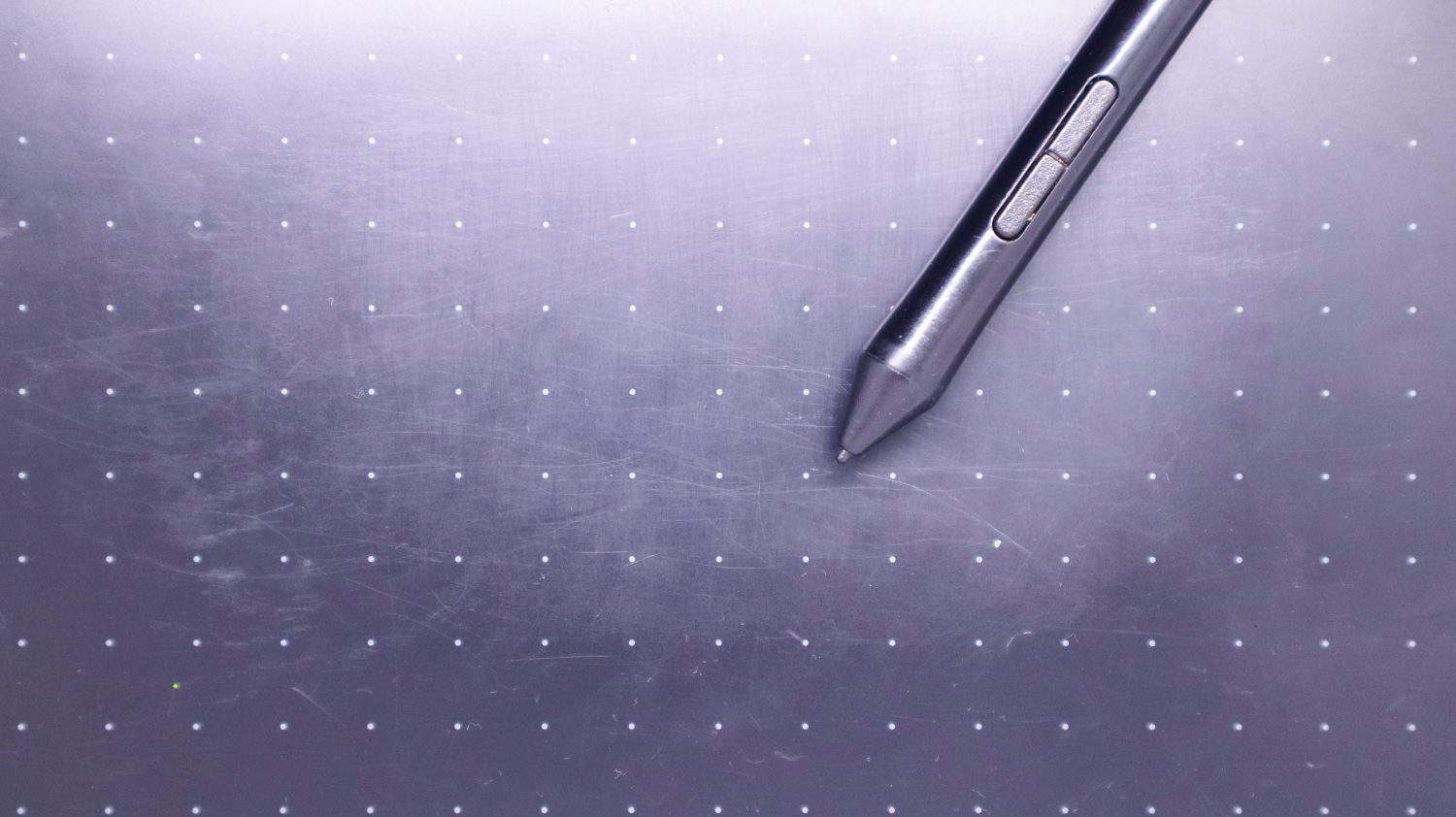 Close-up view of an old black tablet pen or smartpen that has been used on the surface of the tablet with a dot pattern that is full of scratches from use. Modern pen technology.