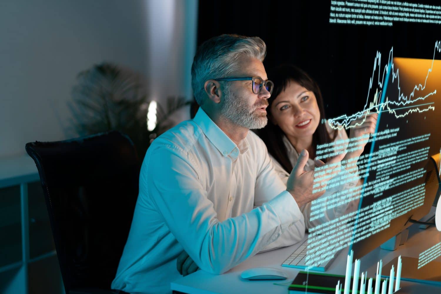 Two Business Professionals Analyzing Data On Digital Screen, Discussing Future Trends And Strategies In Modern Office, Focused Collaboration And Innovation In Technology.