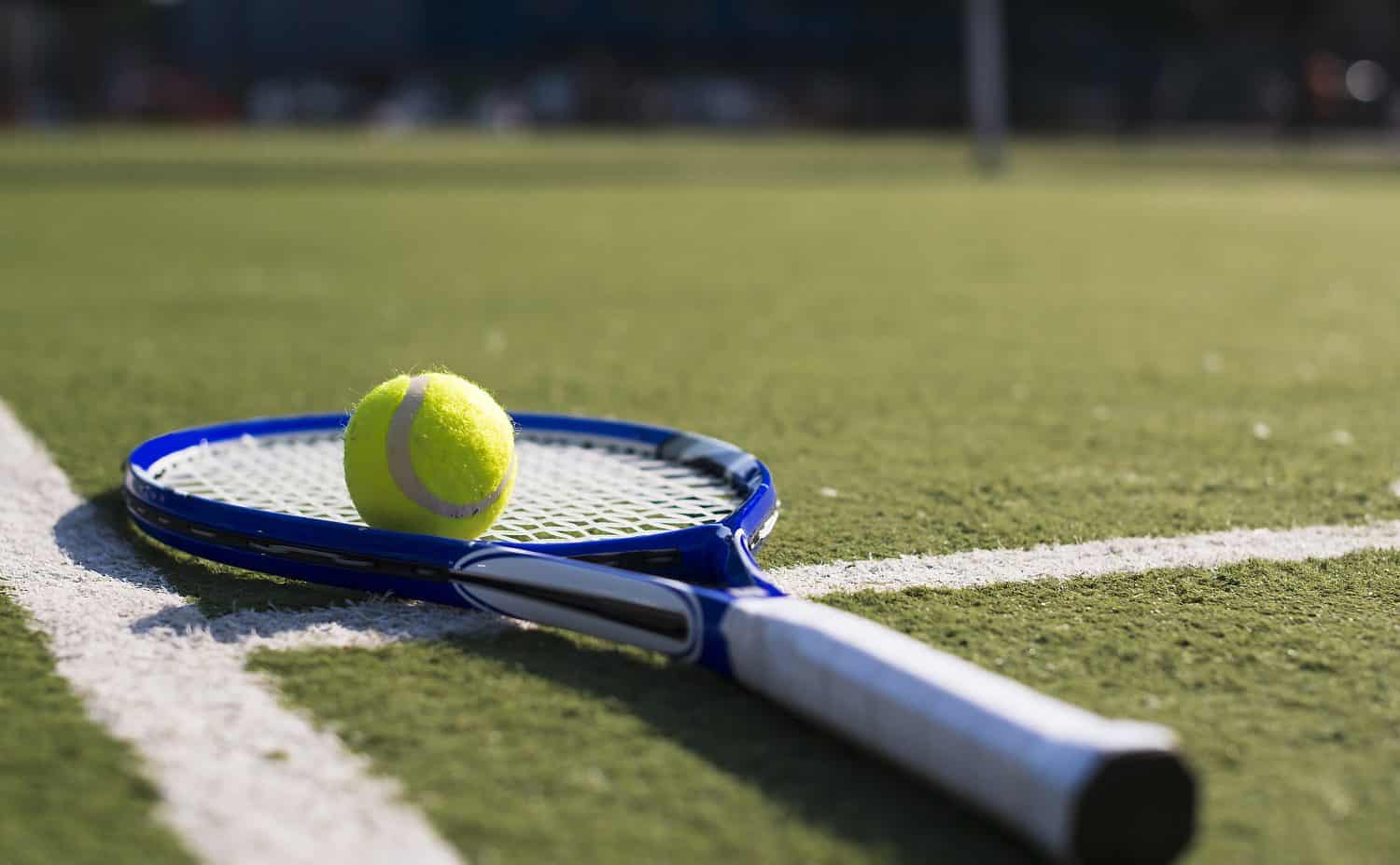 Vintage Tennis Racket With A New ball On The Freshly Painted Tennis Court On White Line, Handle And Strings Of A Tennis Racket Photographed On A Tennis Court With A Ball.