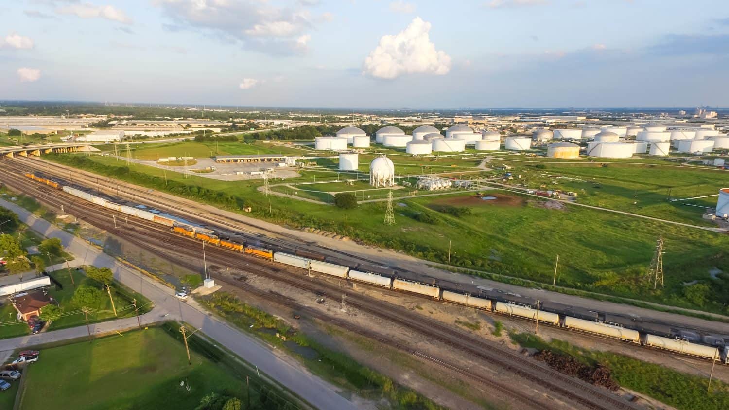 Aerial view of tank farm for bulk petroleum and gasoline storage next to rail line from Northeast of Houston. Crude oil storage terminal, pipeline operations, distributes petroleum products. Panorama.