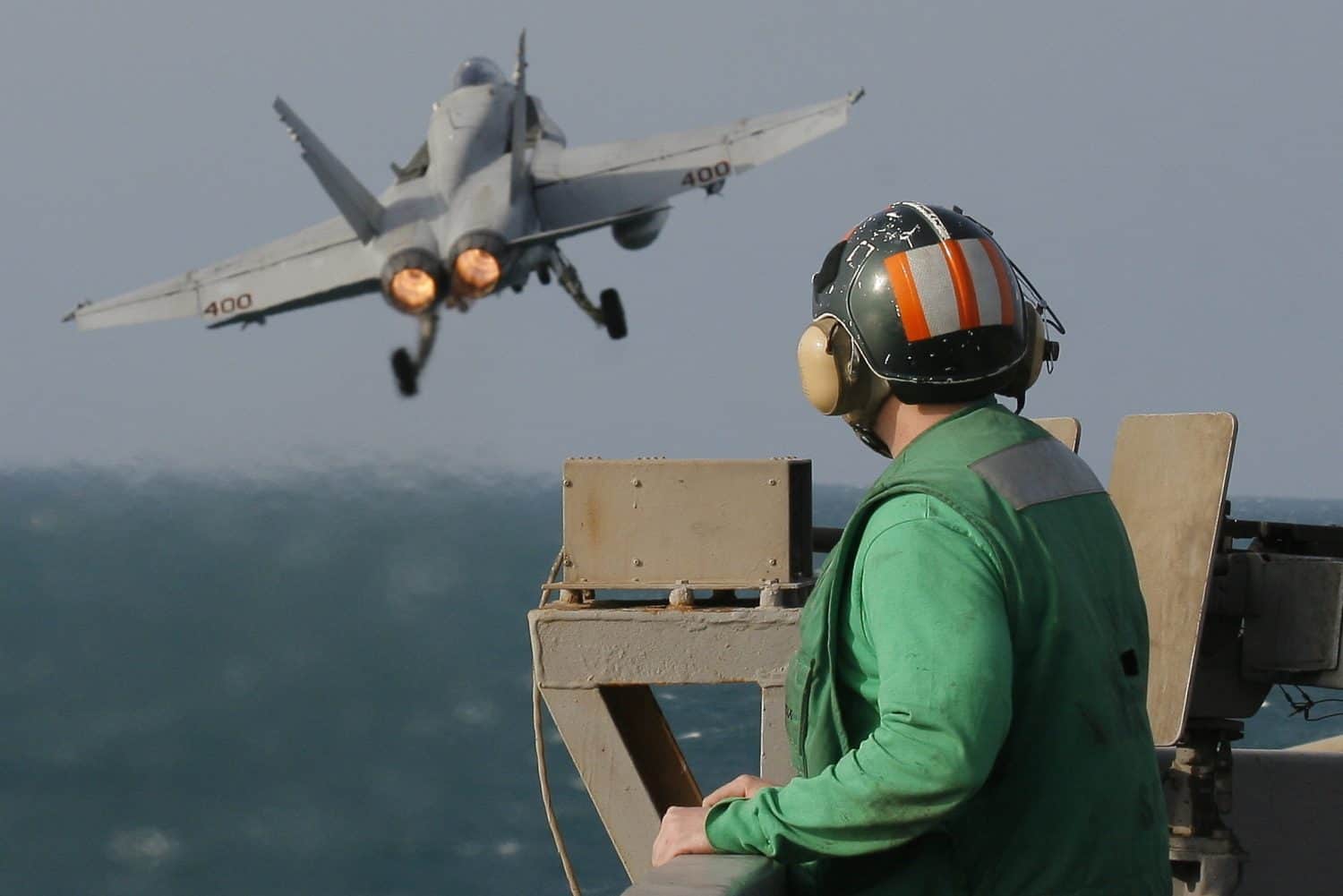 A Catapult Crewman Watches an F/A-18C Hornet Launch From the Nuclear Aircraft Carrier, USS Enterprise