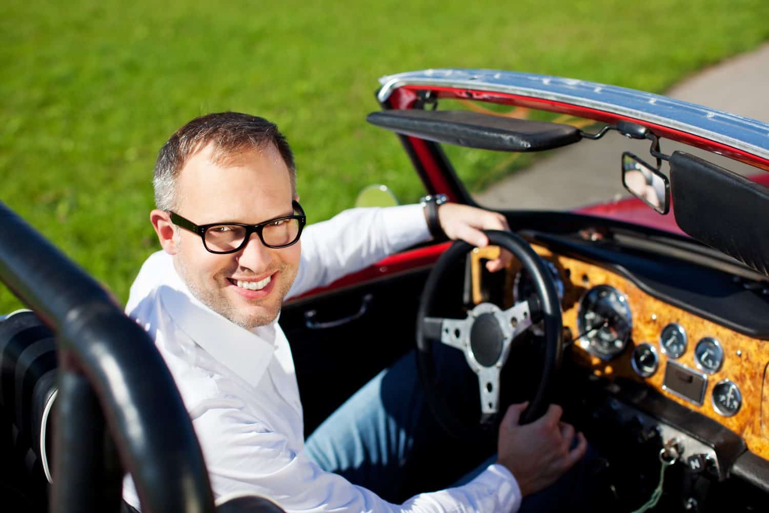 Young smiling man travelling with his convertible car