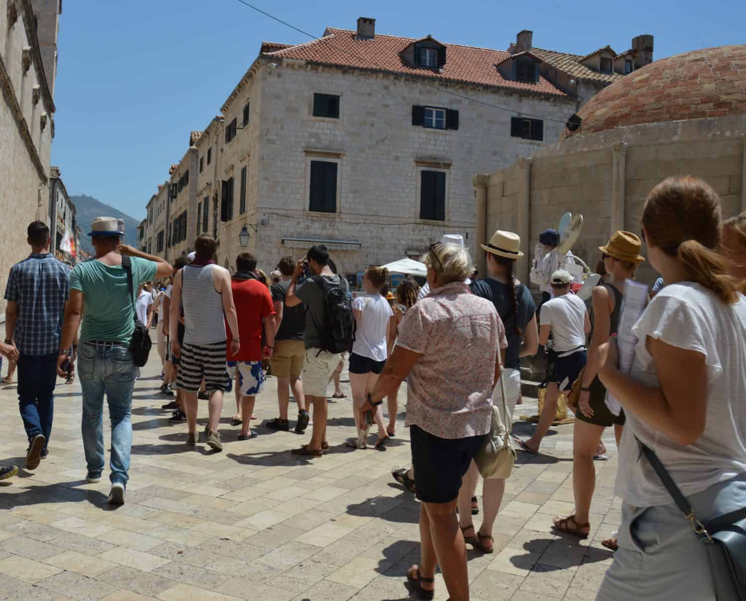 Tourist crowd walking on the street of old town Dubrovnik, Croatia. The walled city is a popular travel destination and world heritage site.