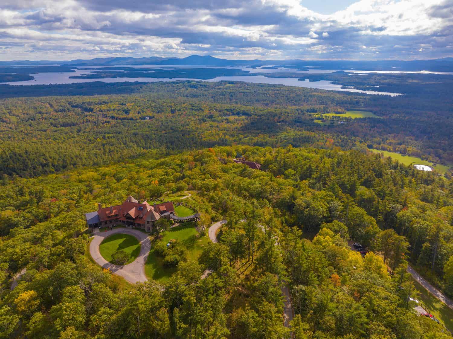 Castle in the Clouds aka Lucknow mansion aerial view in fall at the top of Lee Mountain with Lake Winnipesaukee and Ossipee Mountains at the background in town of Moultonborough, New Hampshire NH, USA