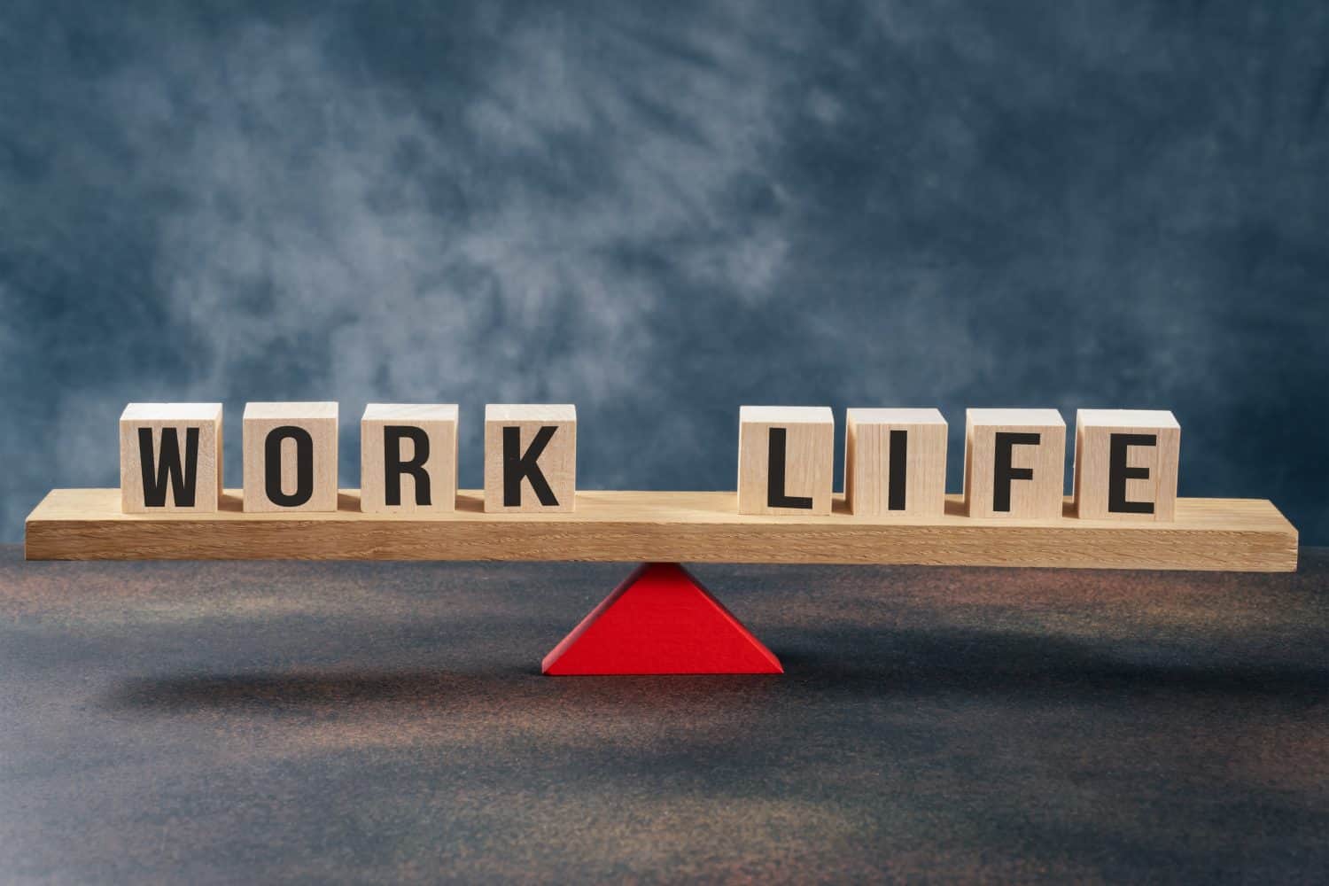 Work and life balane on a wooden seesaw on gray background