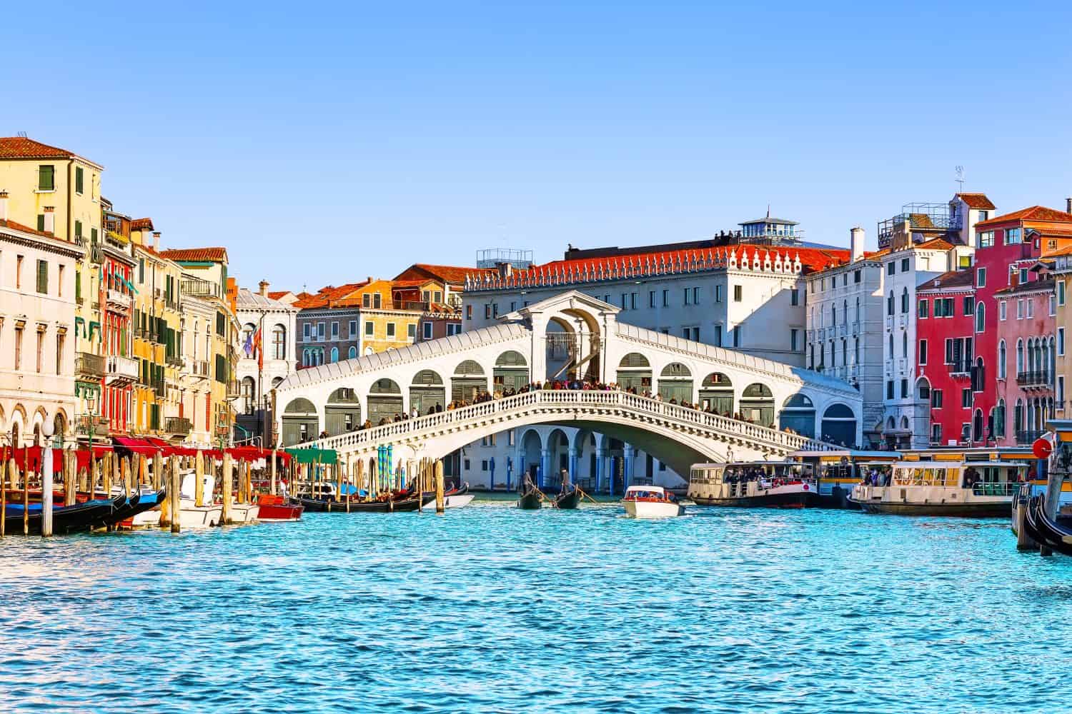 View of Grand Canal with Rialto Bridge and gondoliers in Venice, Italy. Landscape with Rialto Bridge and gondola on the Grand Canal in Venice, Italy, Europe.