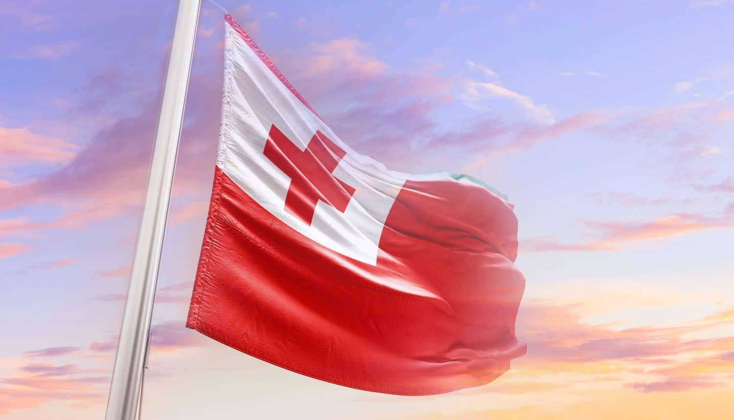 Tonga national flag blowing with mast. The flag waving in beautiful sky. Tonga national flag for independence day.