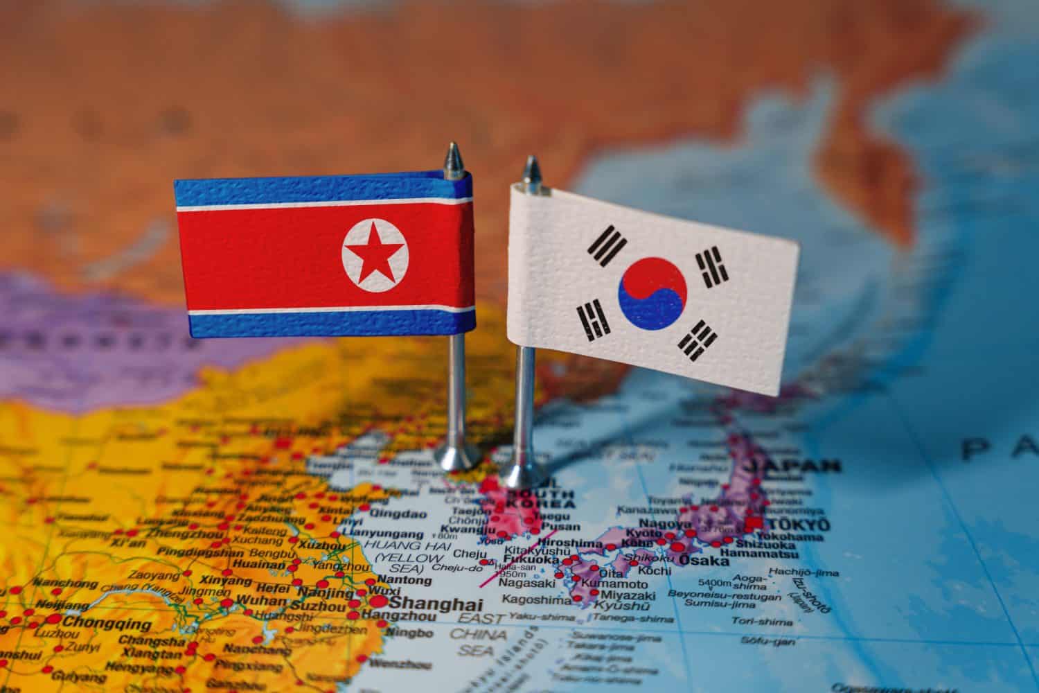 Flags of South Korea and North Korea on geopolitical map. South Korea versus North Korea conflict concept. High quality photo