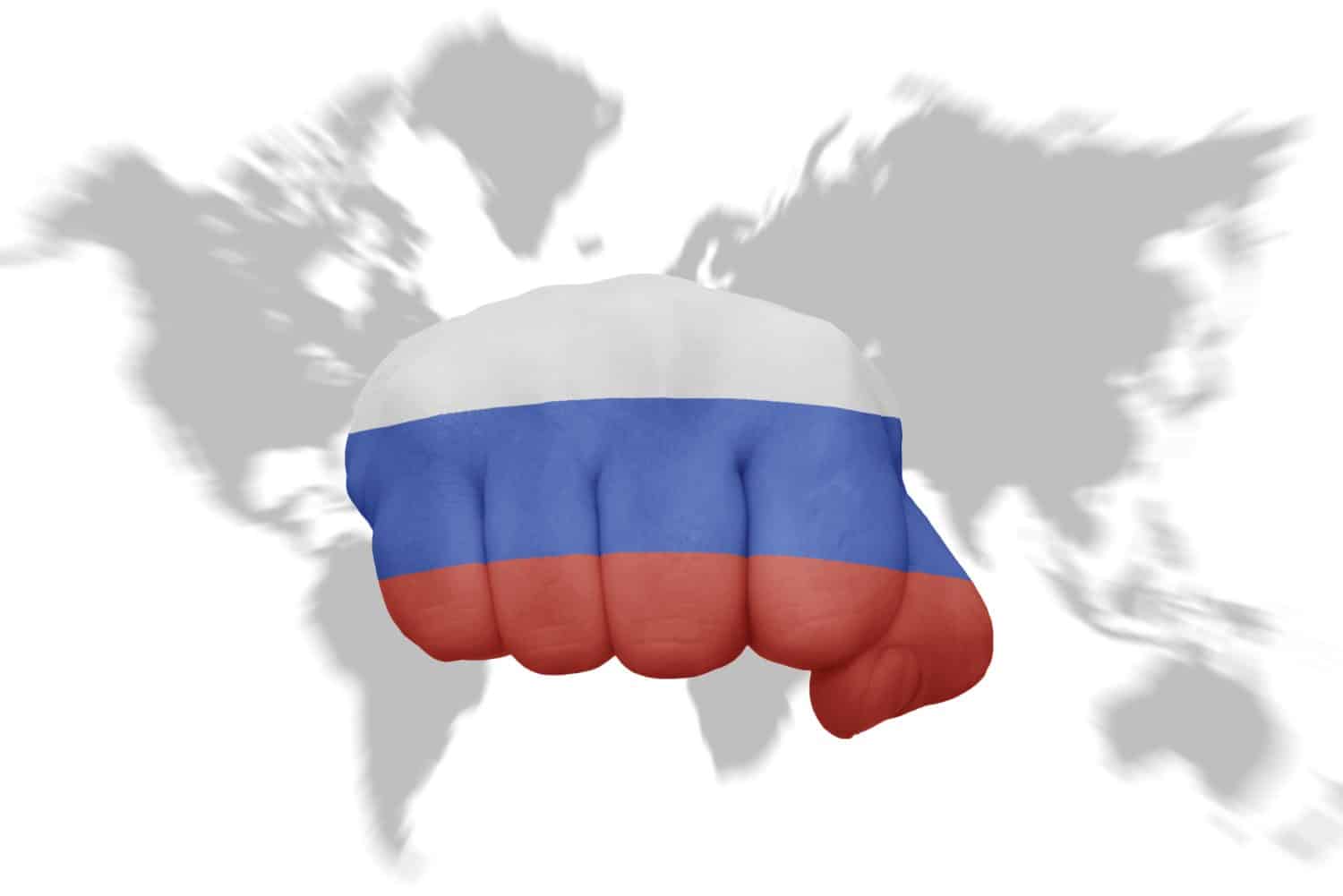 fist with the national flag of russia on a world map background