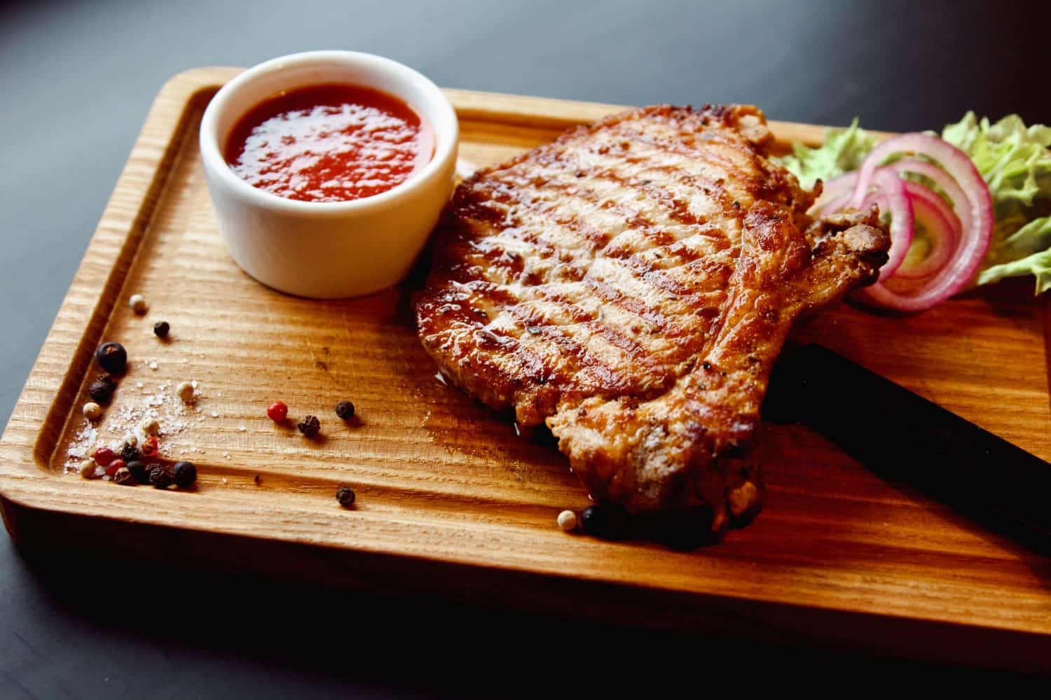 Beautiful juicy pork steak cooked on the grill with caramelized onions