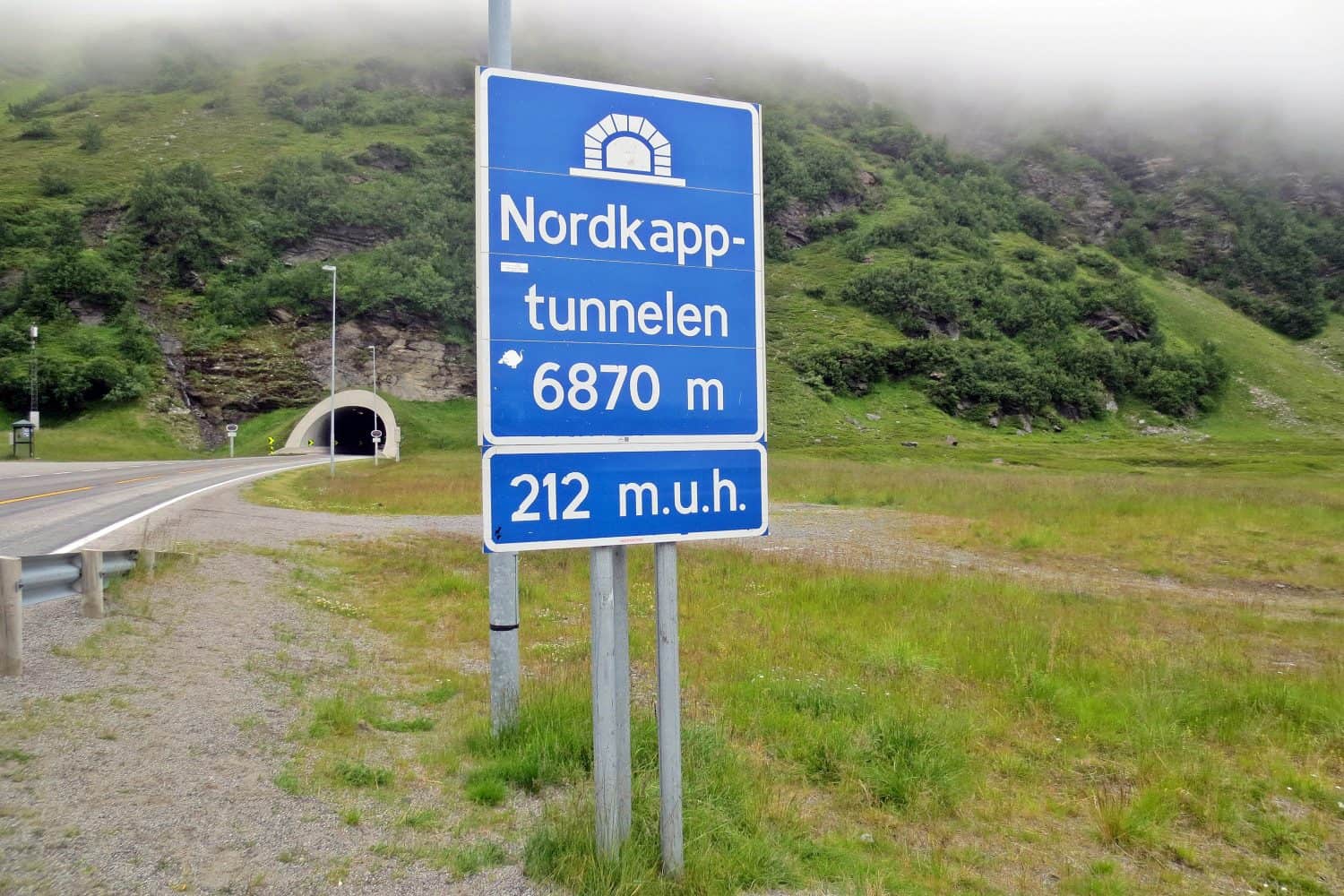 A sign in Norwegian showing the name (Nordkapptunnelen means the North Cape tunnel), the distance and the elevation of the tunnel (m.u.h. means meters under the sea level)