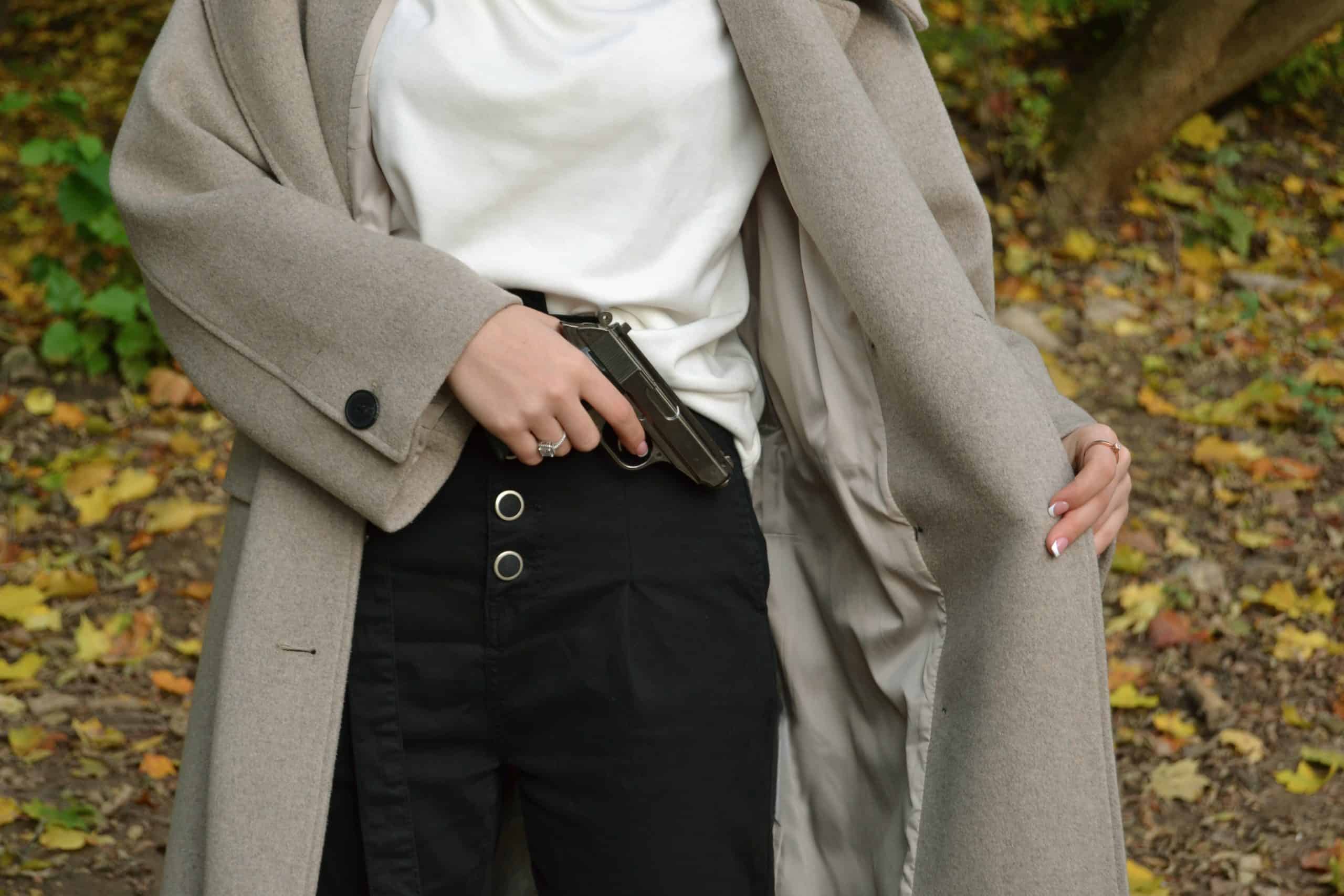 Rear view of a young woman with gun.