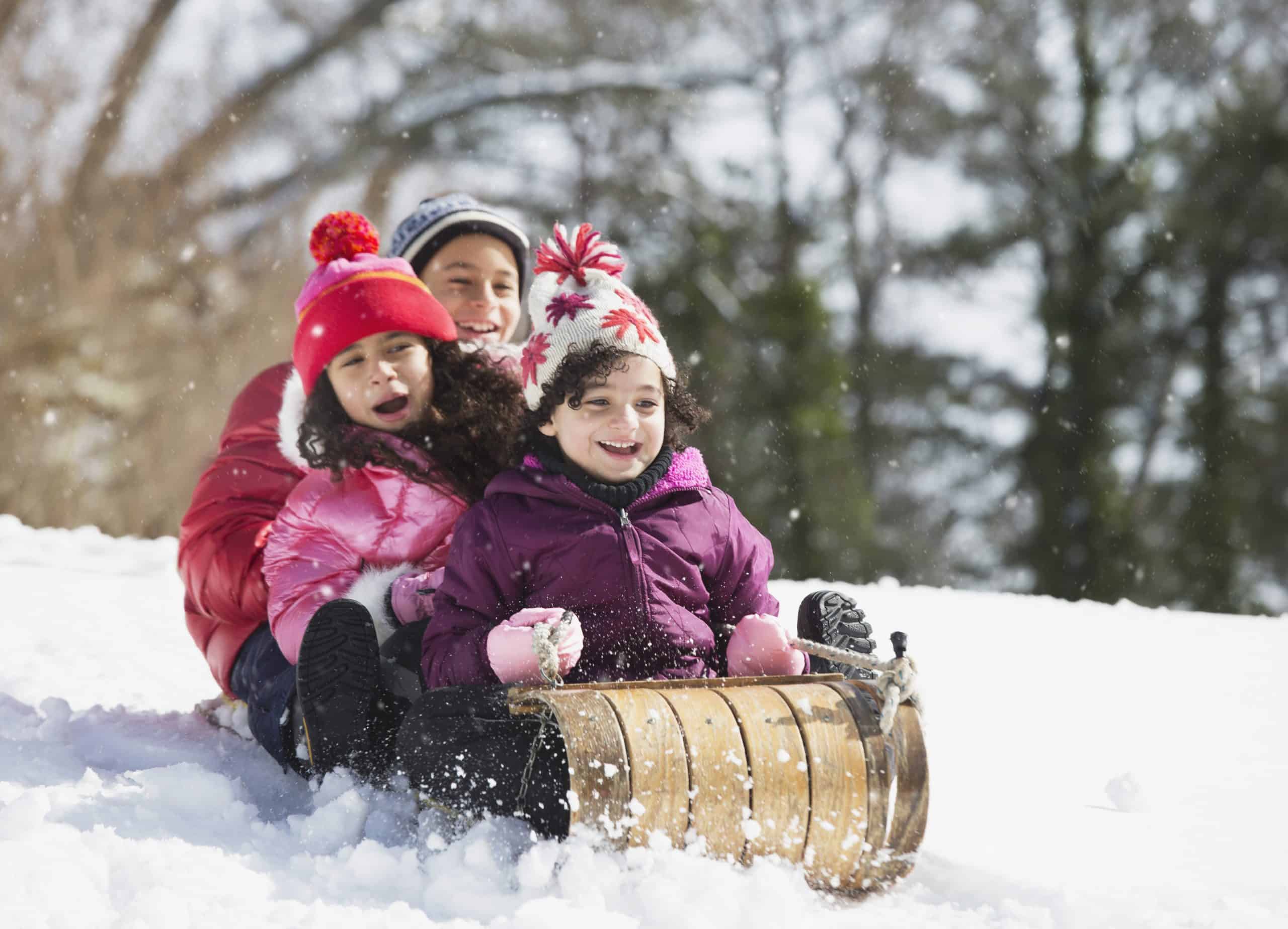 Hispanic family sledding in snow