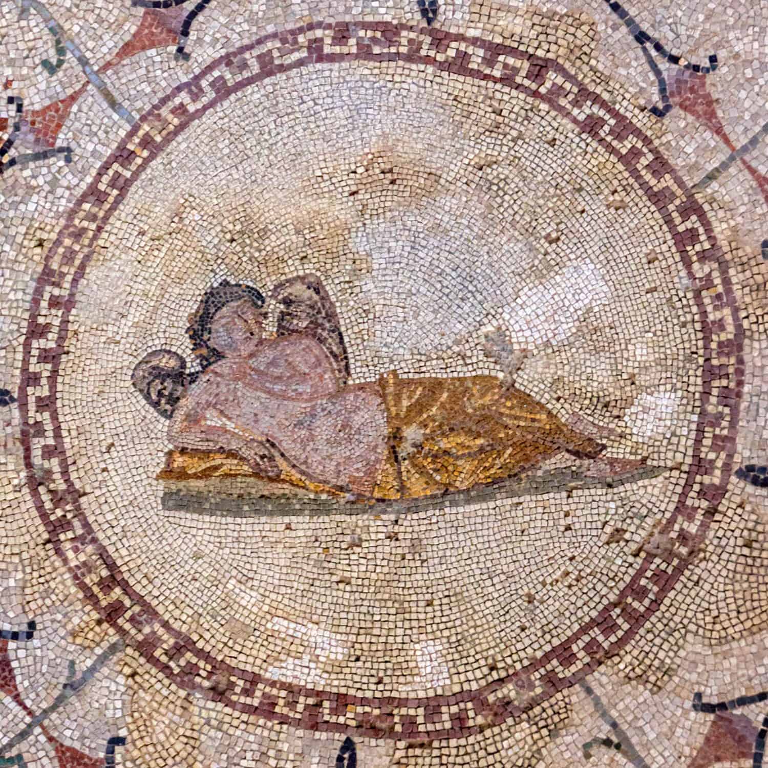 Floor mosaic of colored stones with the god of sleep Hypnos - young man with wings, lying on pillow, museum &quot;Roman mosaics&quot;, Risana, Boca-kotor bay, Montenegro