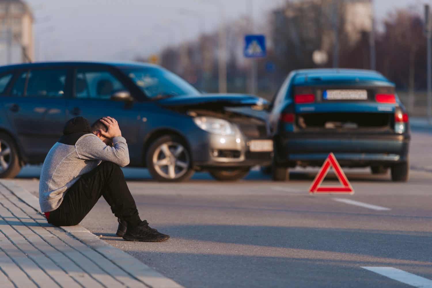 A man is looking desperate after two cars crashing on the road by his fault