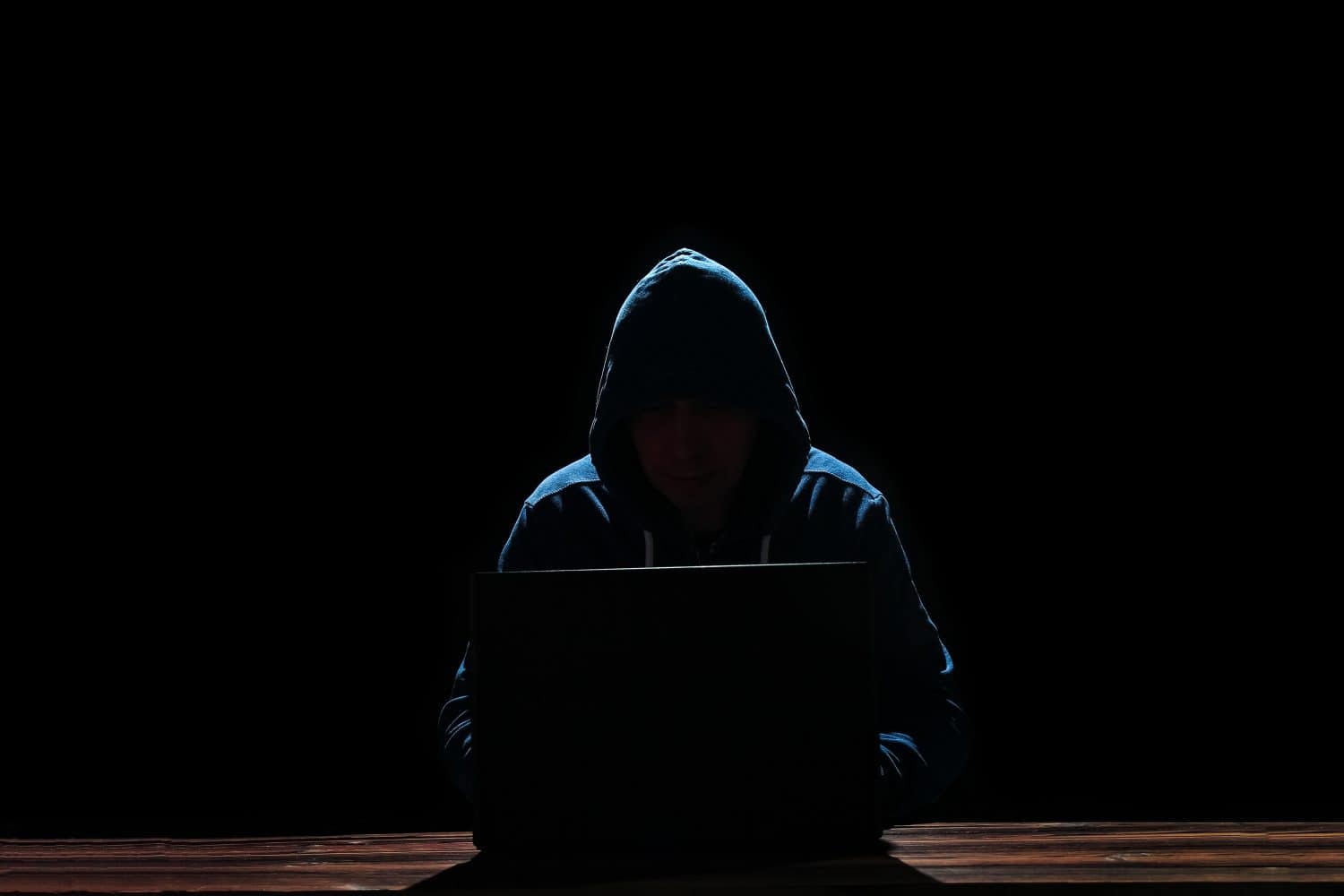 hacker with laptop on black background