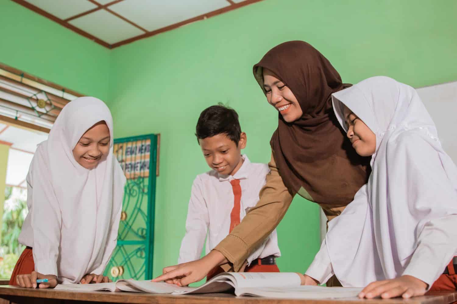 Indonesian school students with their teacher have a discussion in the class