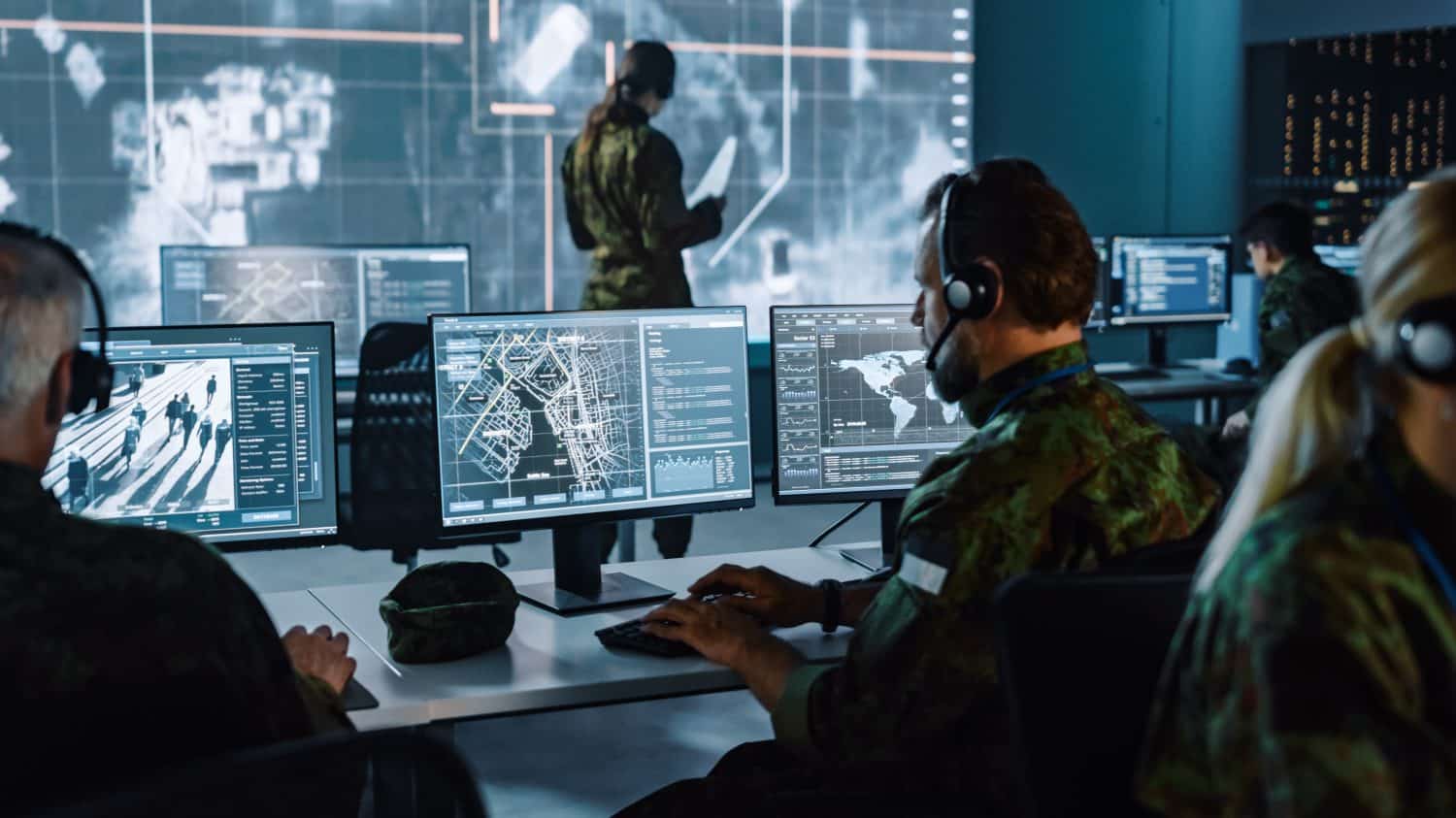 Military Surveillance Officer Working on a City Tracking Operation in a Central Office Hub for Cyber Control and Monitoring for Managing National Security, Technology and Army Communications.