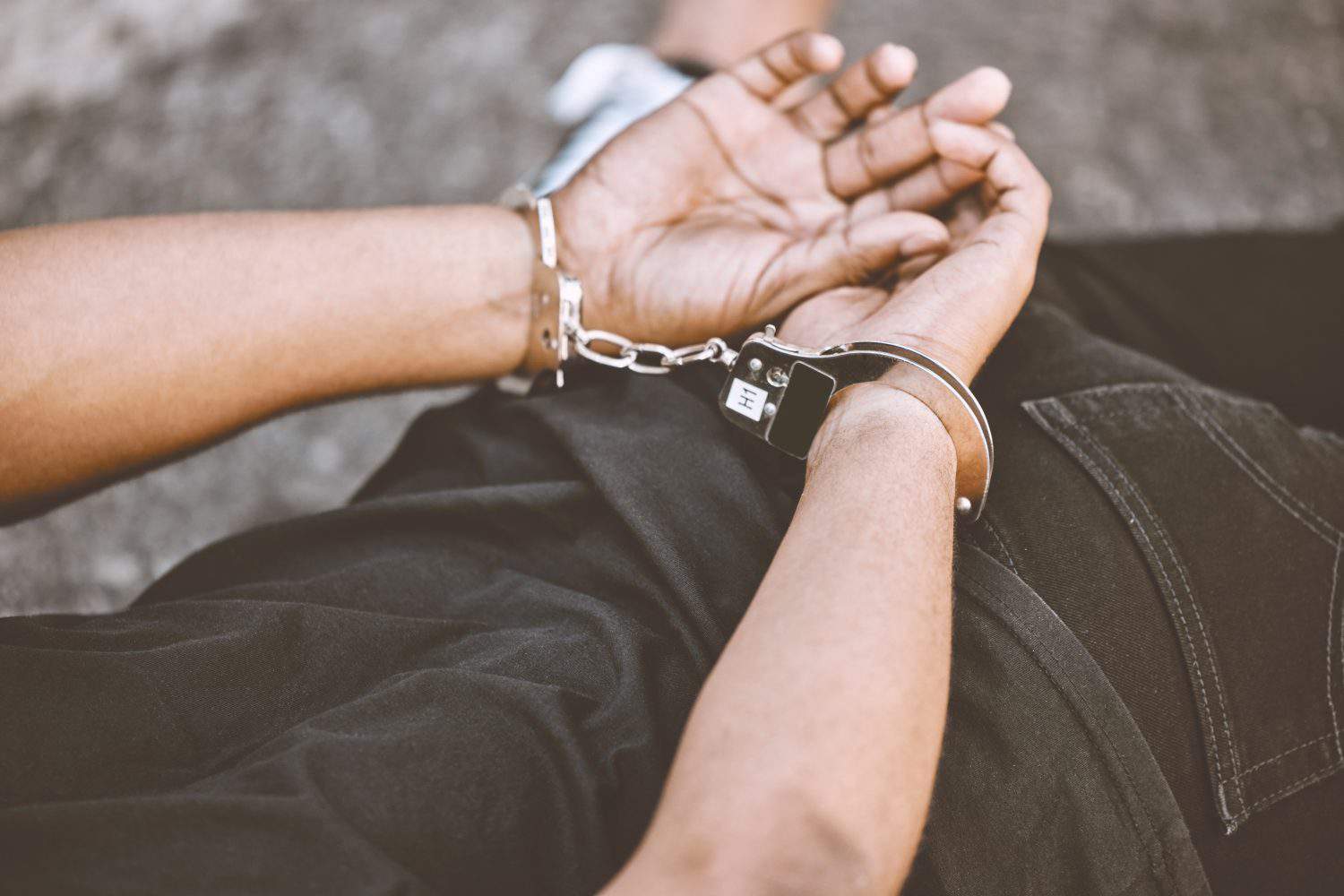 Arrest, justice and thief in handcuffs for fraud, violence and burglary after a suspected house robbery. Law, hands and gangster criminal going to jail or prison for violence and crime in Venezuela