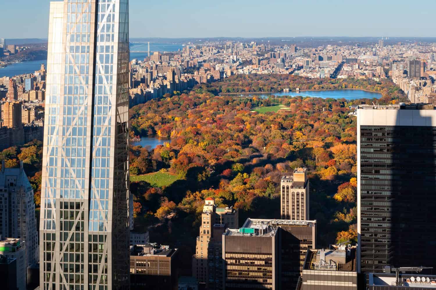 Aerial view of Central Park in full Fall colors with new supertall building and skyscrapers of Midtown Manhattan. New York City