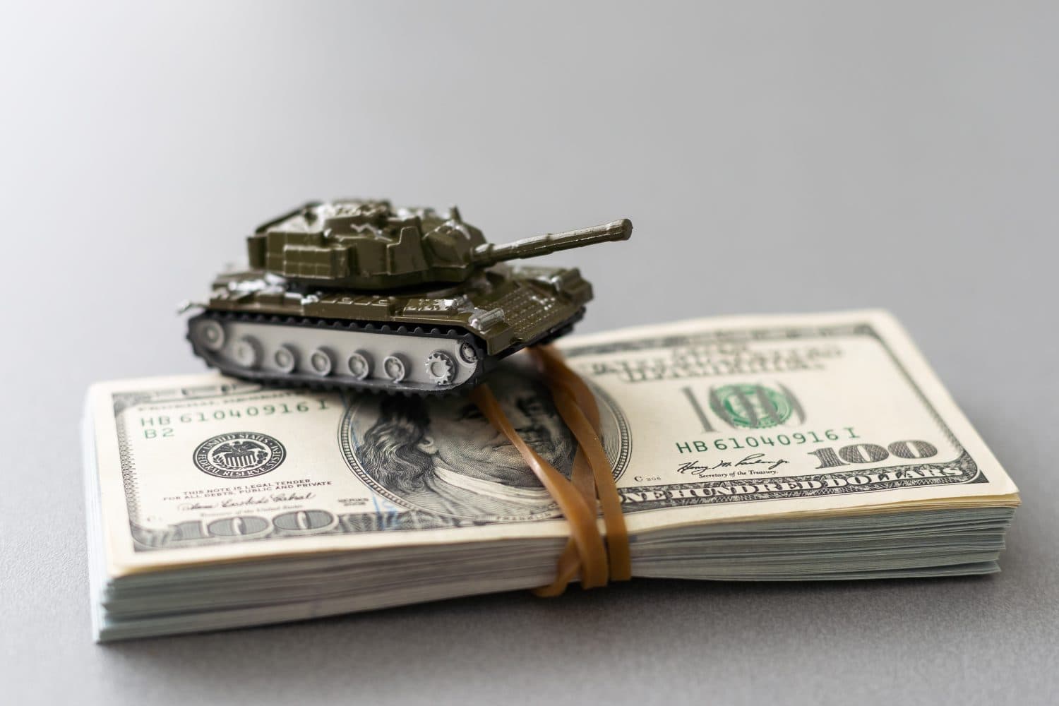 toy tank on the background of dollar bills