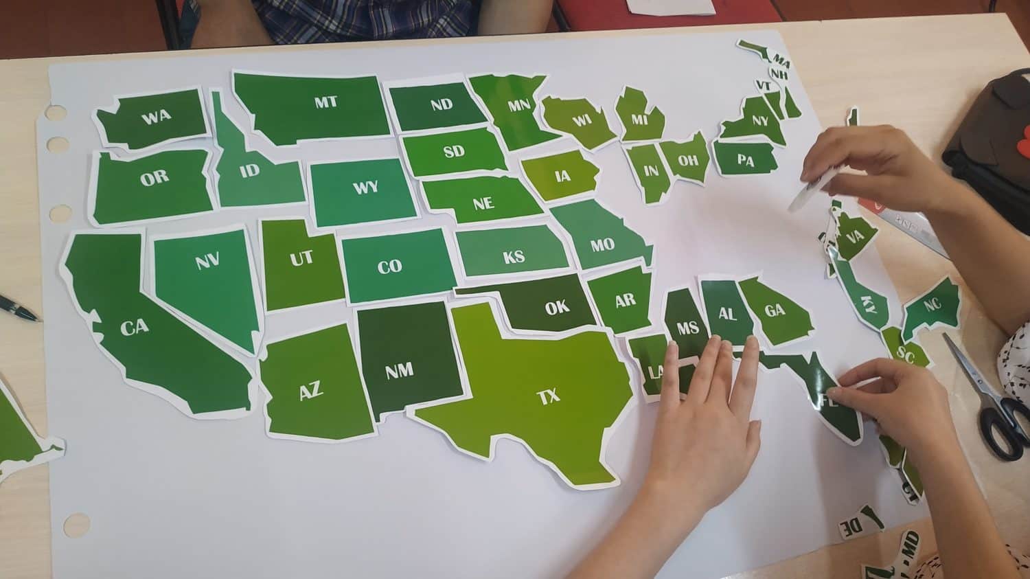 The students (pupils) are puzzling out the US map.