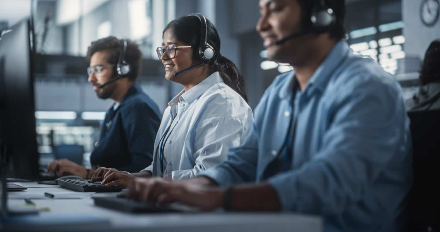 Positive Technical Support Managers Talking on Calls, Providing Help Desk Solutions to Customers Experiencing Troubleshooting Issues with a Product. Indian Specialists Successfully Solving Problems