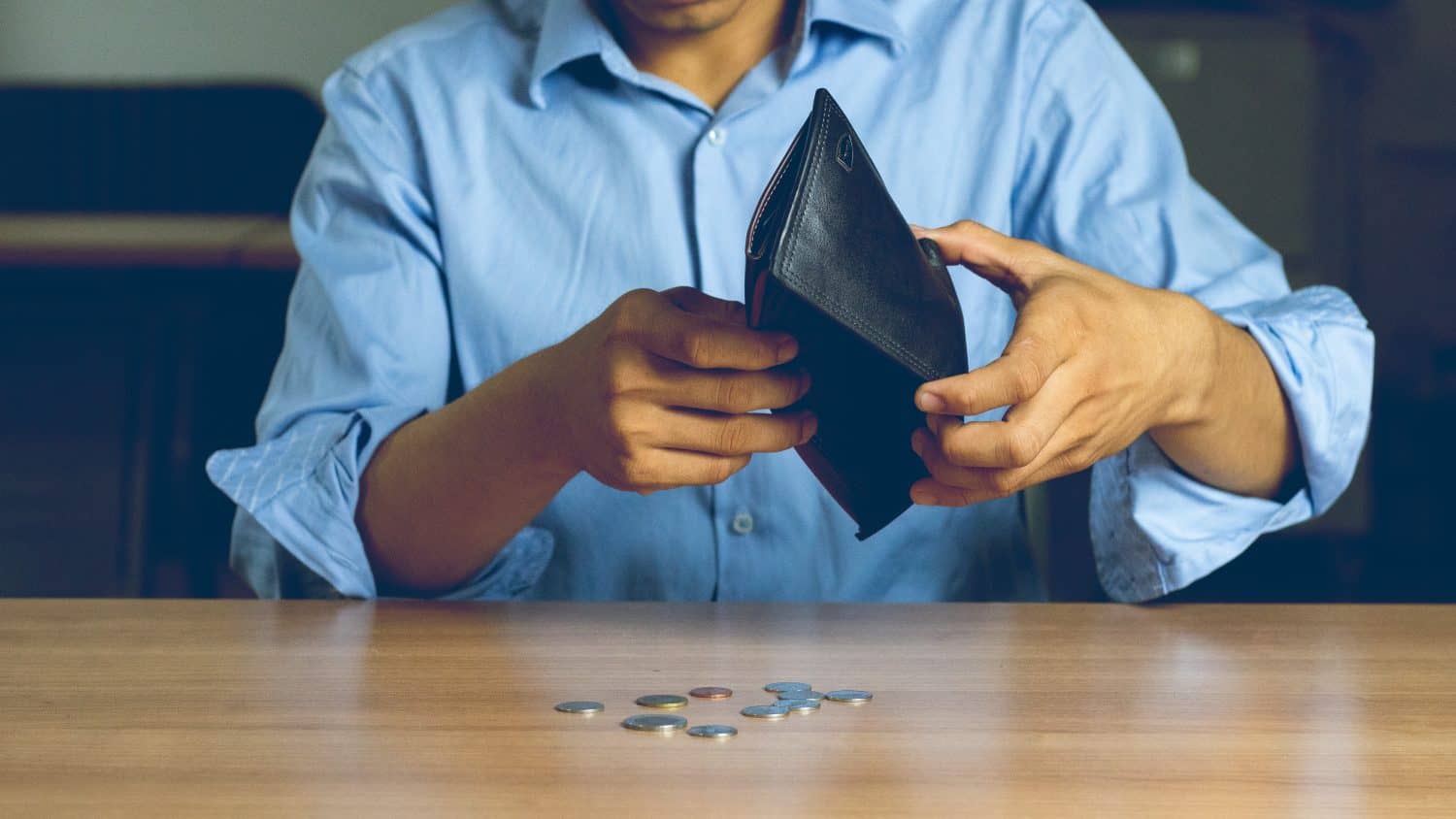 Poor man bankrupt with no credit in debt hand hold empty black leather wallet because economy down turn Empty wallet (no money) in the hands of an man