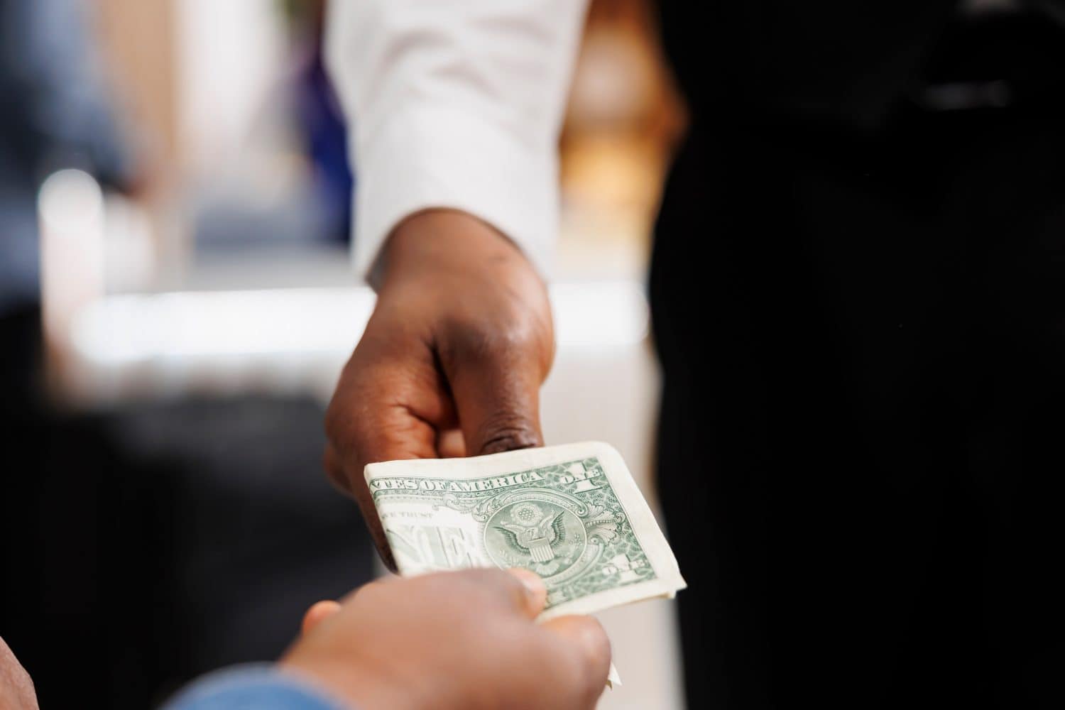 Close up of hospitality worker accepting of cash payment, taking money from customer. Hotel guest holding money paying for services at resort, giving tip to waiter at bar or restaurant