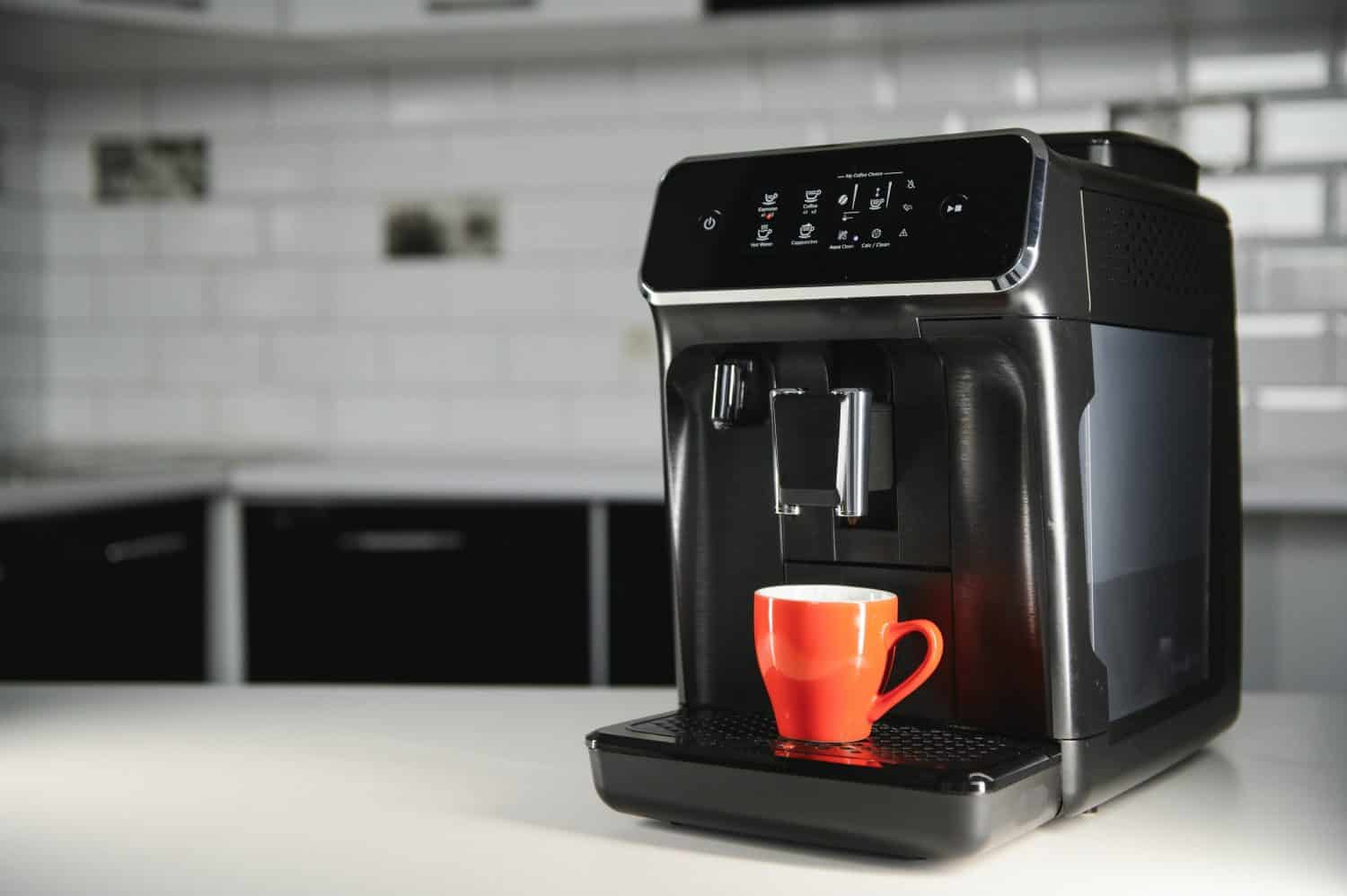 Modern coffee machine on table in kitchen.