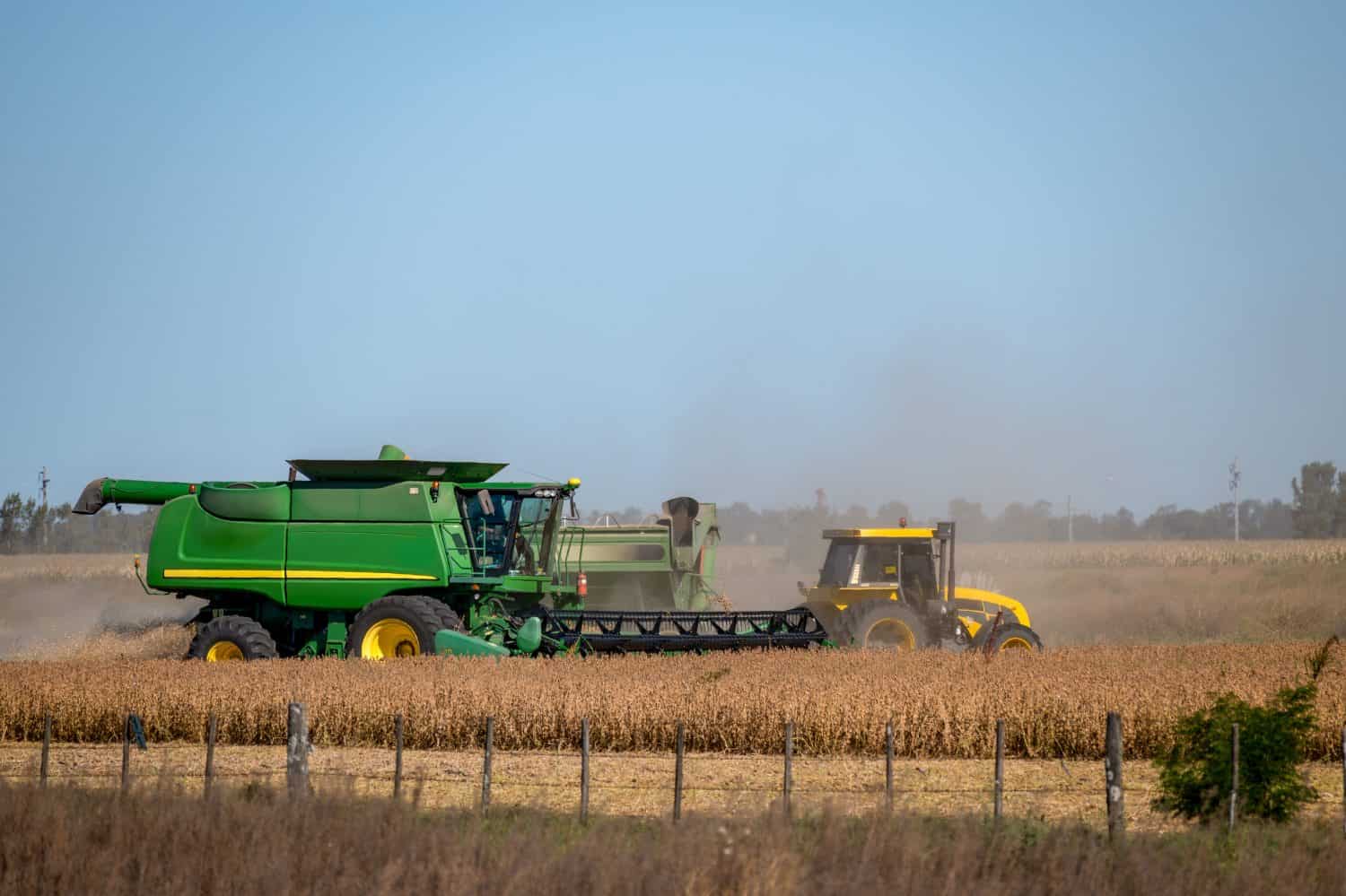 Photo of combine harvesters working during the harvest season in a large field of ripe wheat in Argentina.