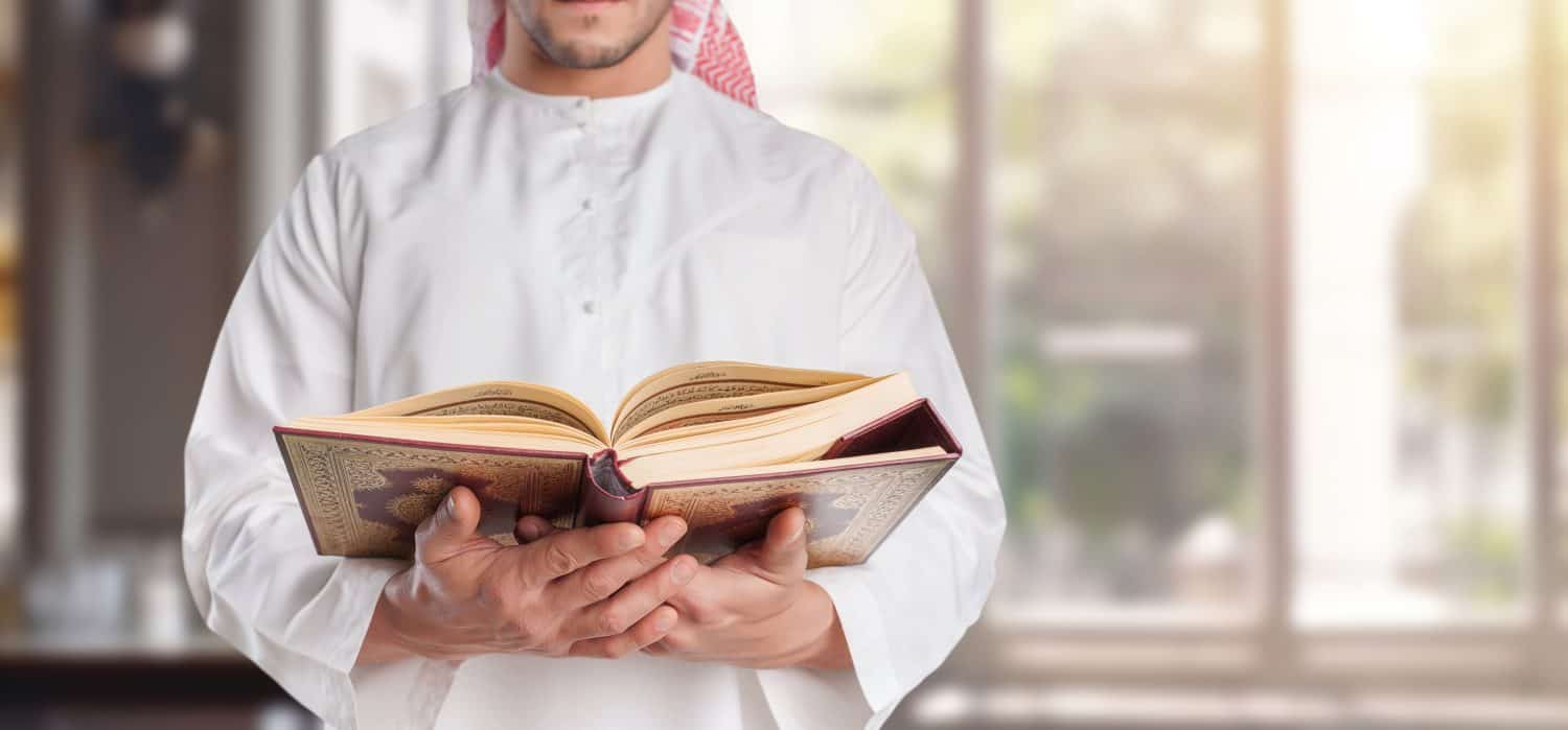 Holy Quran book in Hand Muslim man