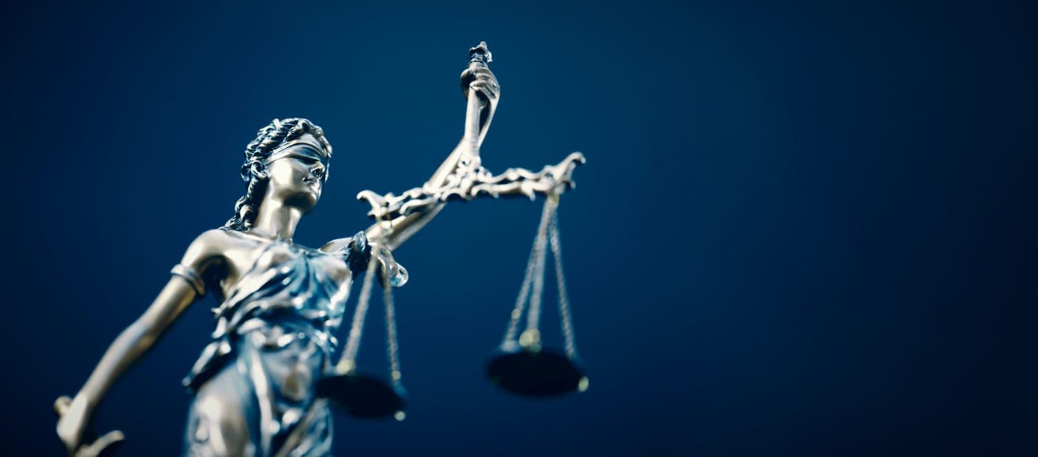 Lady Justice statue in law on blue background. Law and justice concept