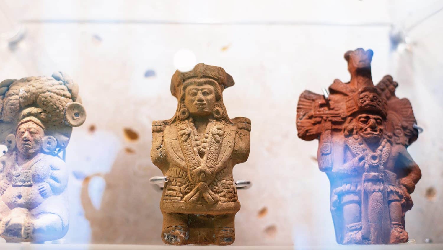 mayan warriors figurines carved in white and red stone represented on the exhibition of Mayan artifacts