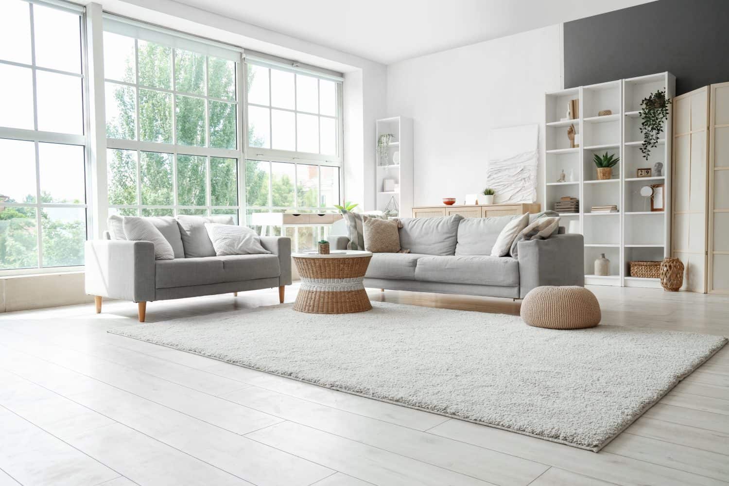 Interior of light living room with sofas, rattan table and soft carpet