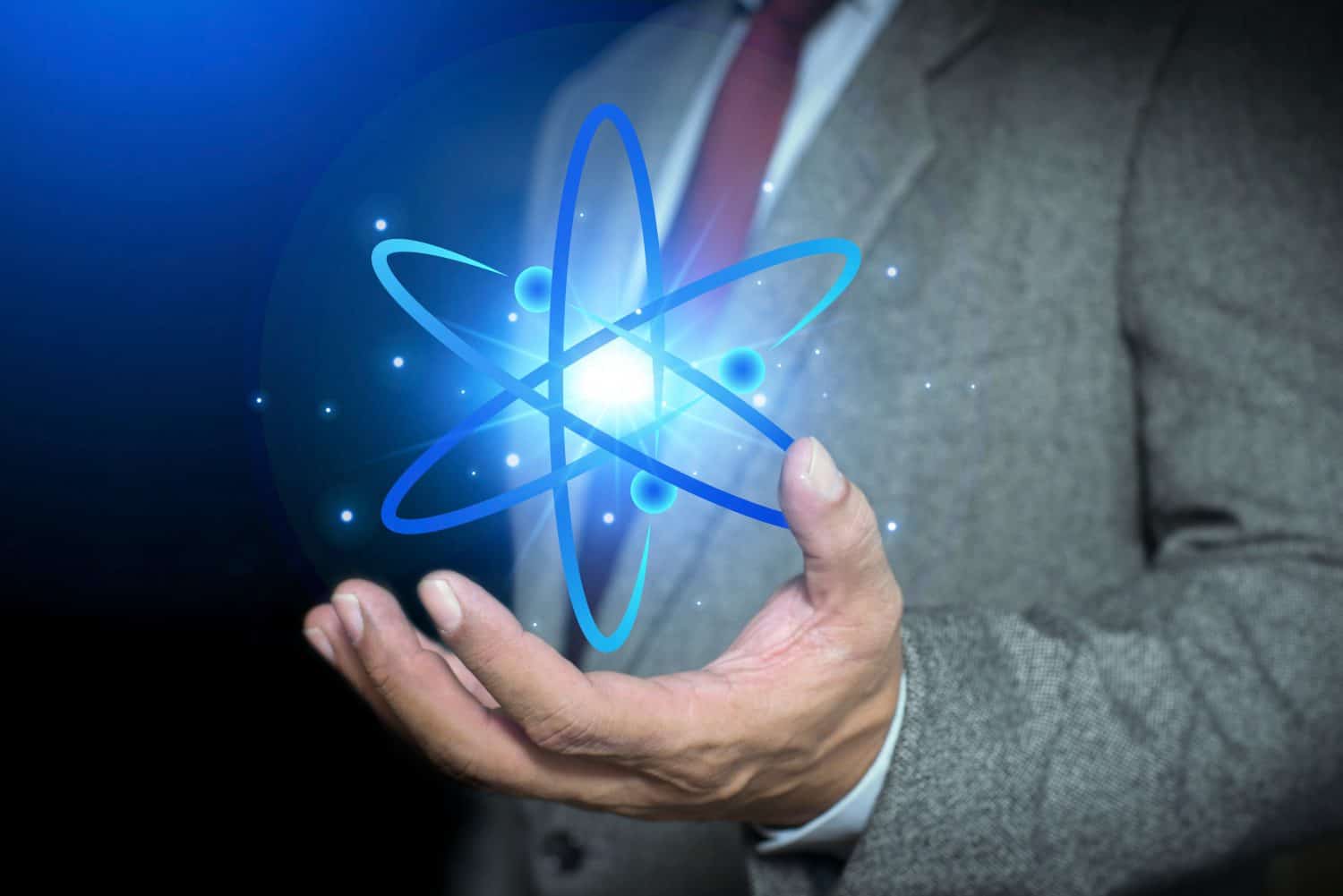 Bussinessman hand holding creative atom. Nuclear fusion concept, endless energy, cheap electricity, future technologies. Science and future concept