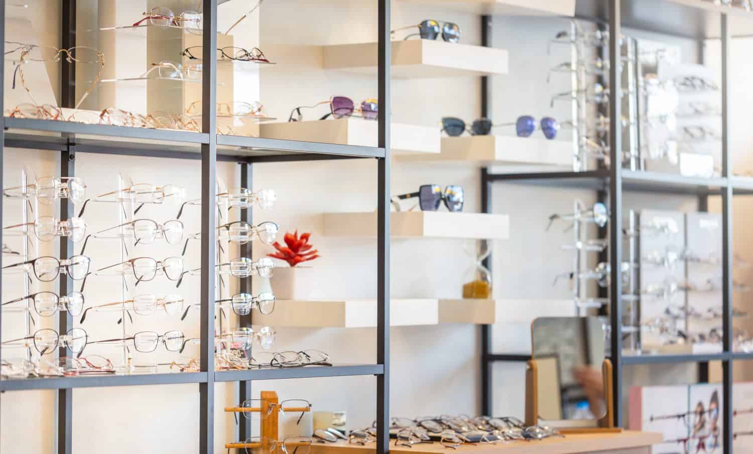 Corrective eye glasses on shelf in optical store, Row of spectacles on shelves in eyeglasses shop