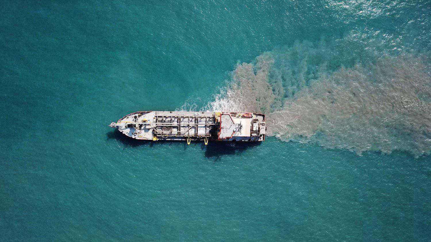 Suction Dredger ship working near the port - with mud, Pollution, brown Muddy water - aerial shot